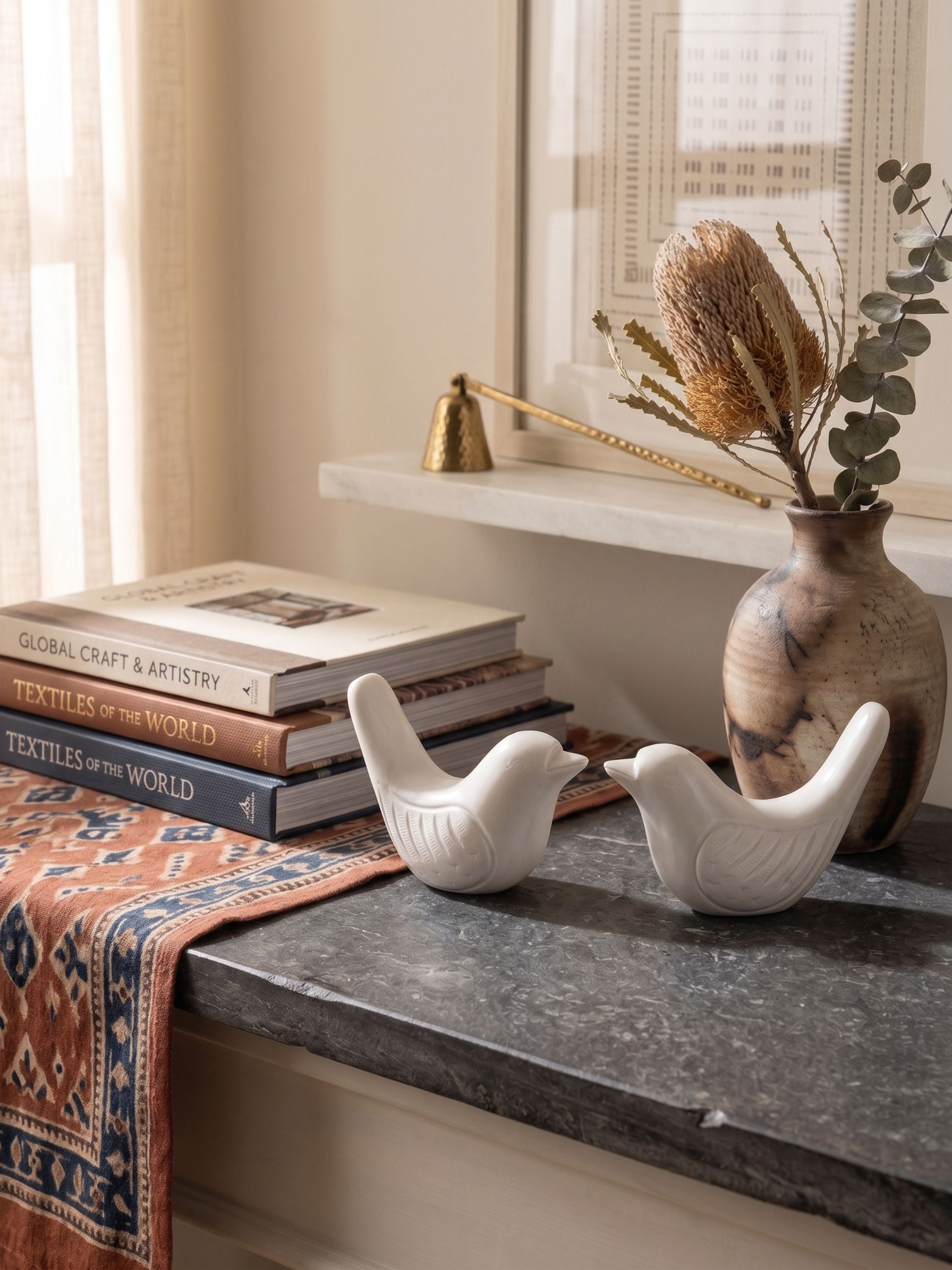 Marble bird figurines set of two styled on a shelf with books and vase in a warm natural interior