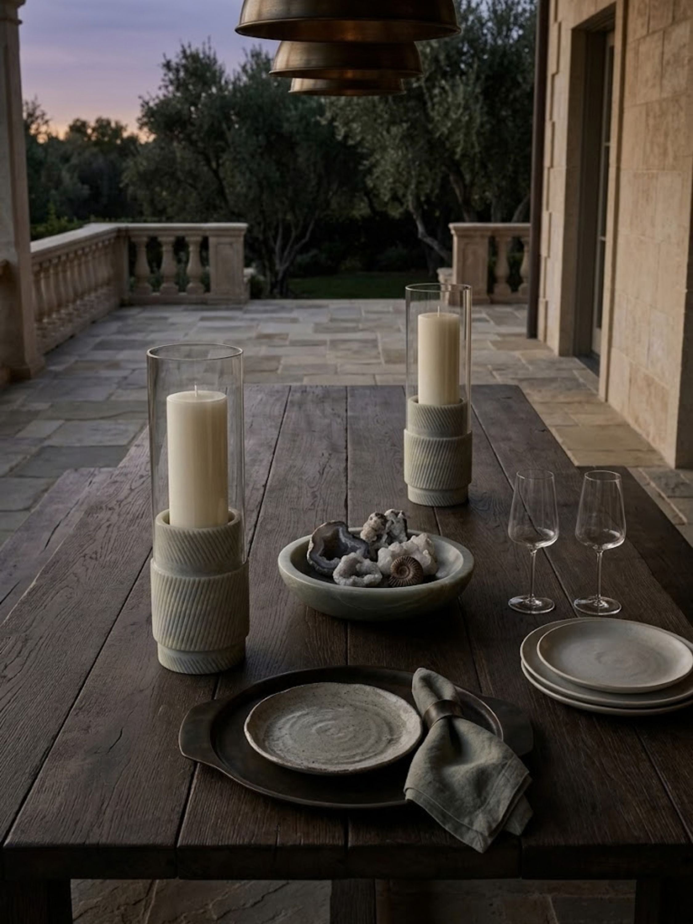 Estonia Green Onyx hurricane candle holders displayed on an outdoor dining table, bringing sculptural presence and soft illumination to open-air gatherings and entertaining.