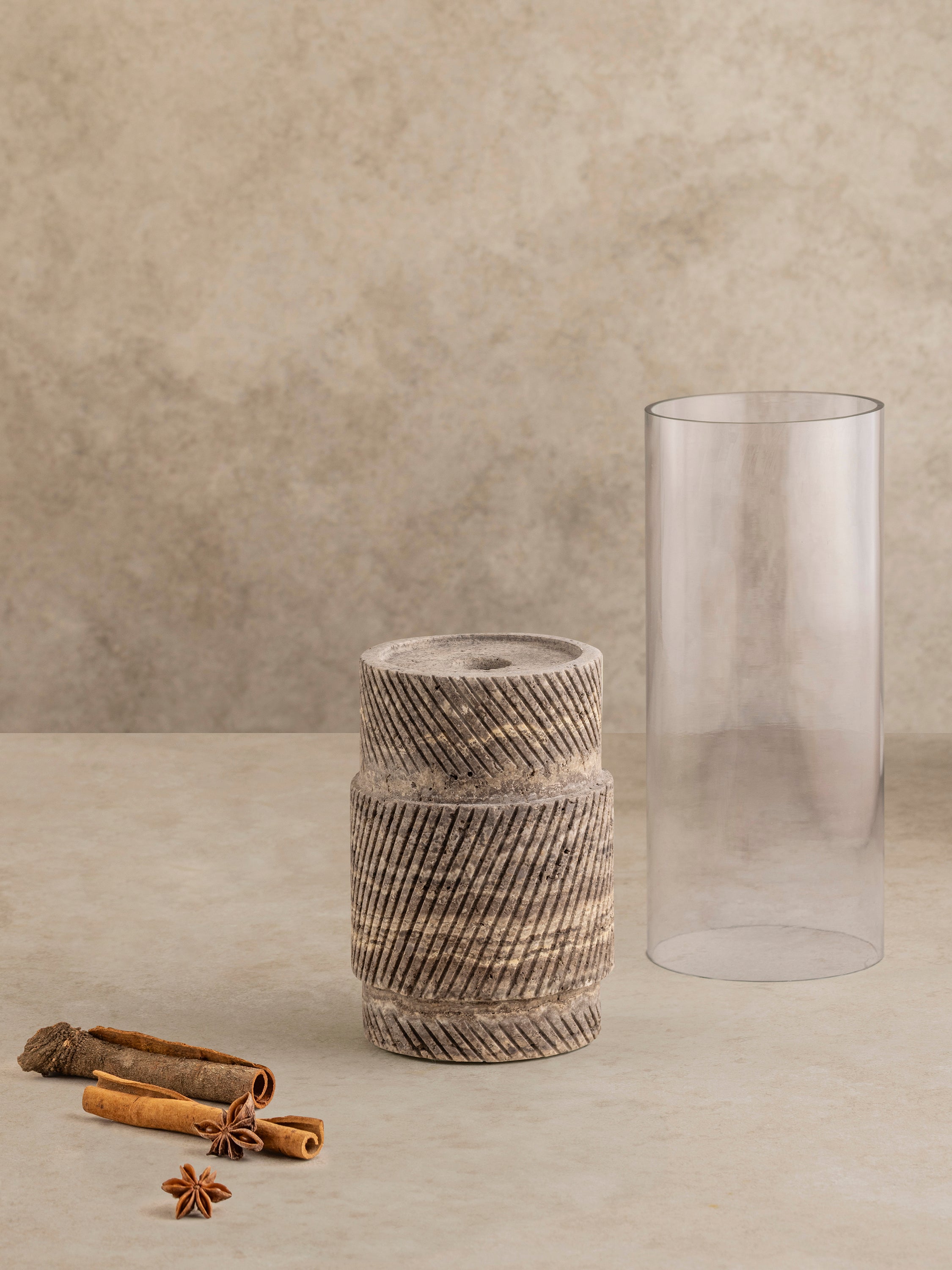 Estonia brown travertine candle holder shown with glass cylinder in place, highlighting warm stone tones and carved base form