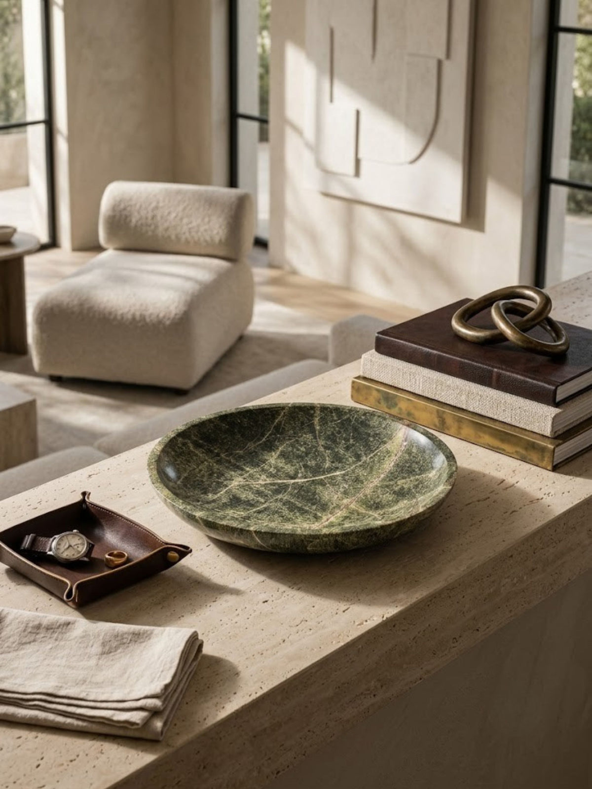 Green marble bowl with a shallow profile, styled on a coffee table.