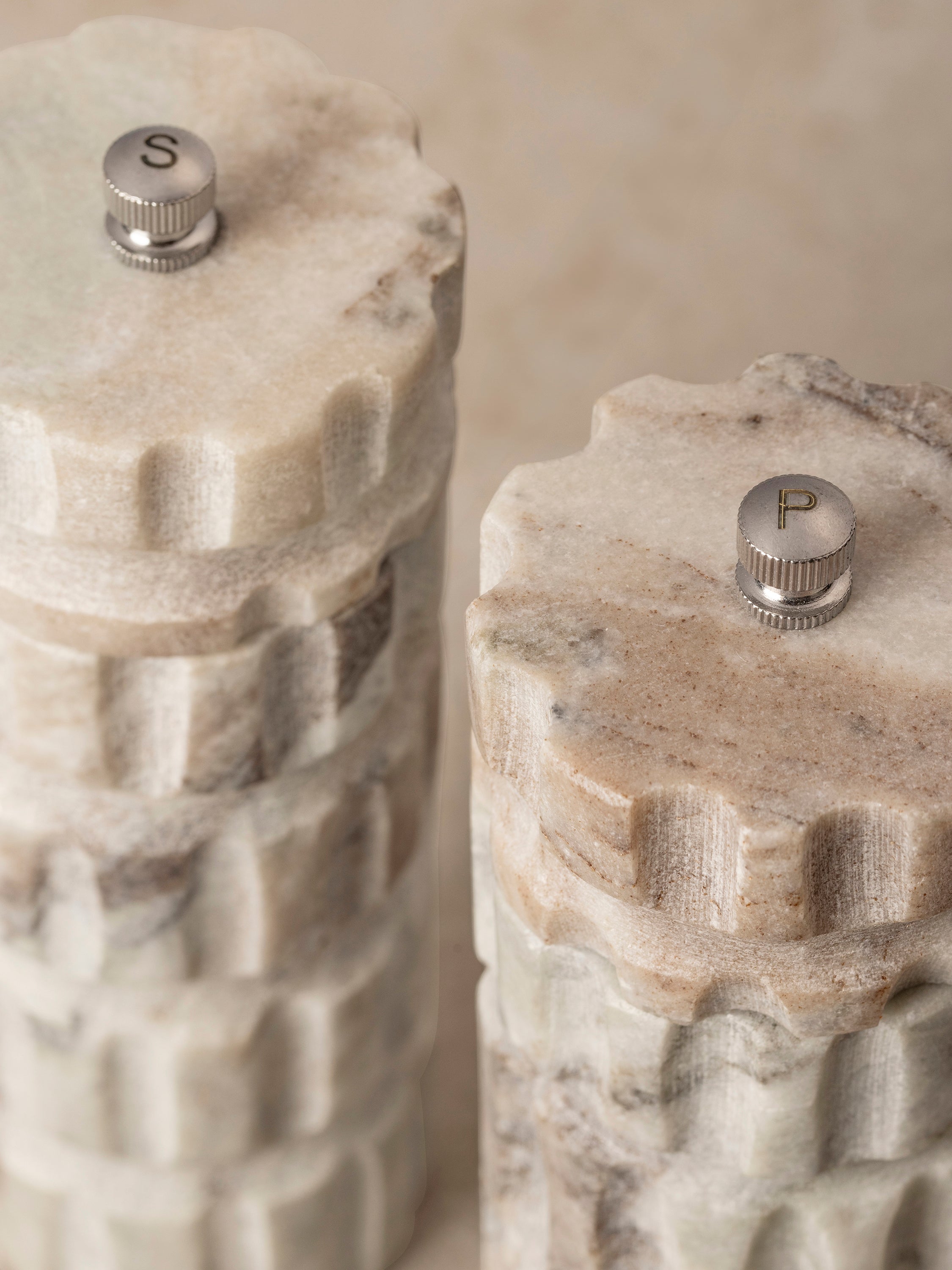 Close-up of a Beatrix mill top showing the metal grind adjustment knob and engraved detailing on the marble surface.
