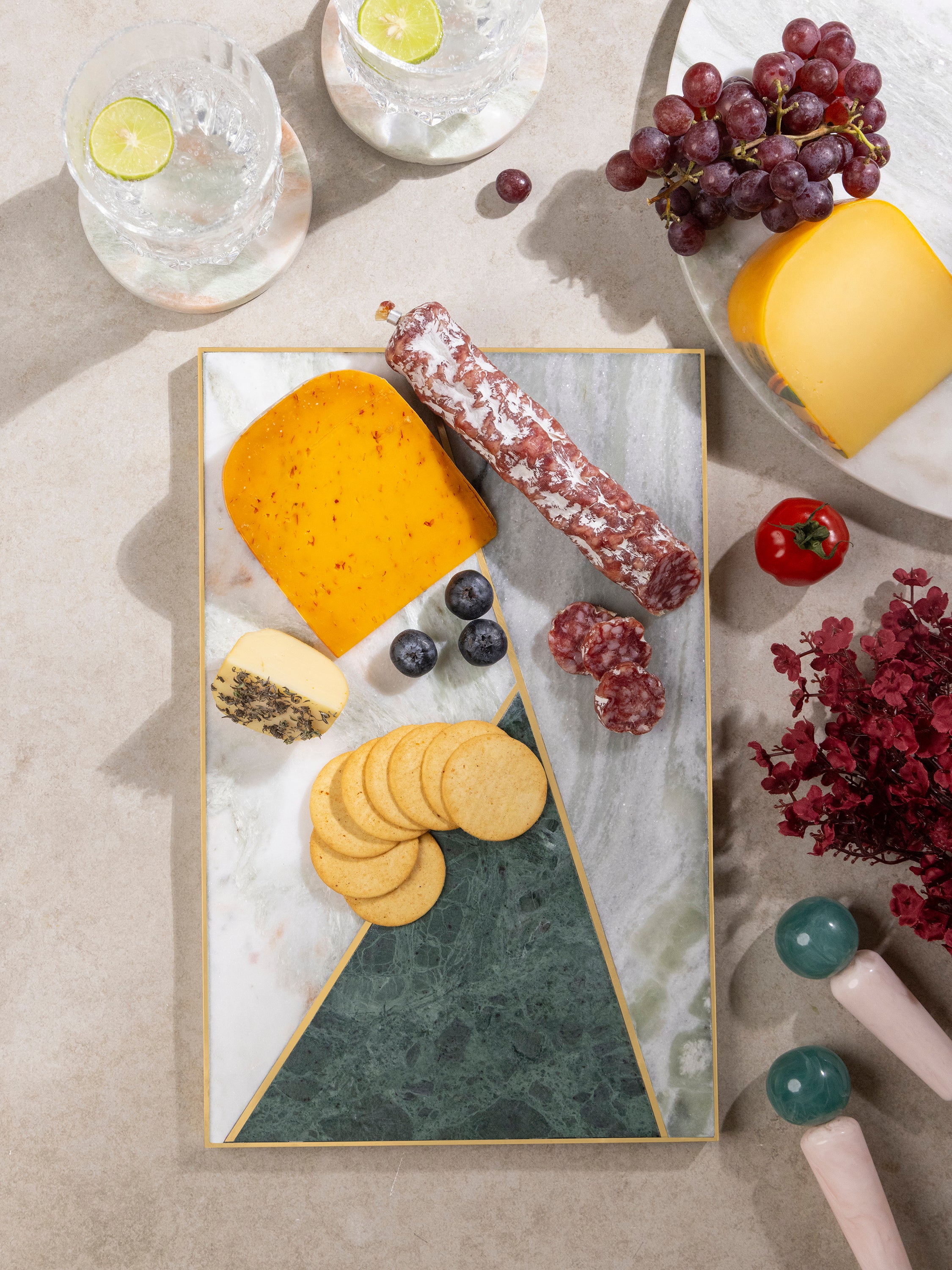 Brno marble cheese board arranged with cheeses, crackers, grapes, and honey beside a garden-view window, bringing timeless elegance to cheese service and gathering spaces.