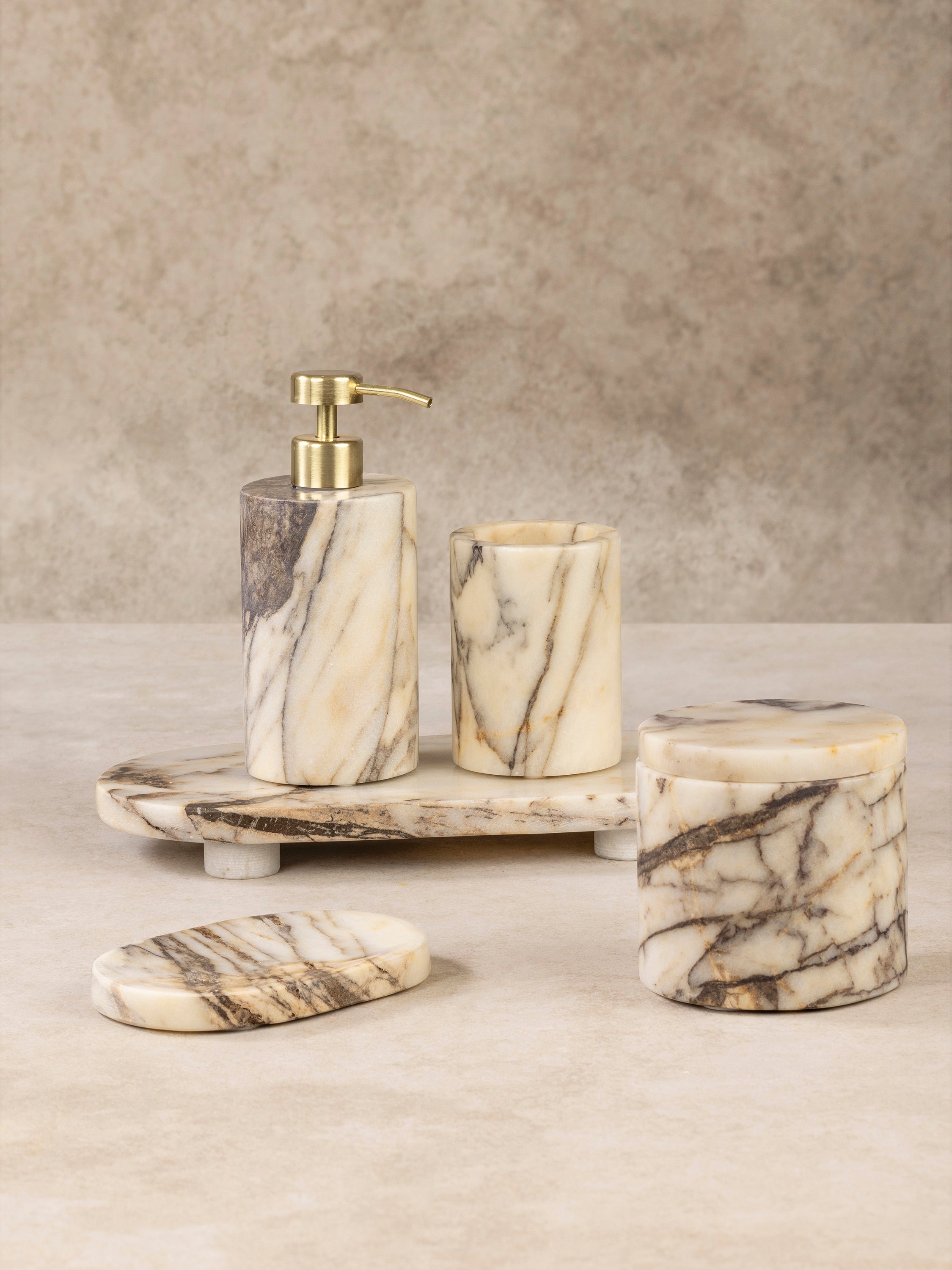 Tangier bath set components arranged together showing cylindrical stone forms with smooth polished surfaces in warm layered tones