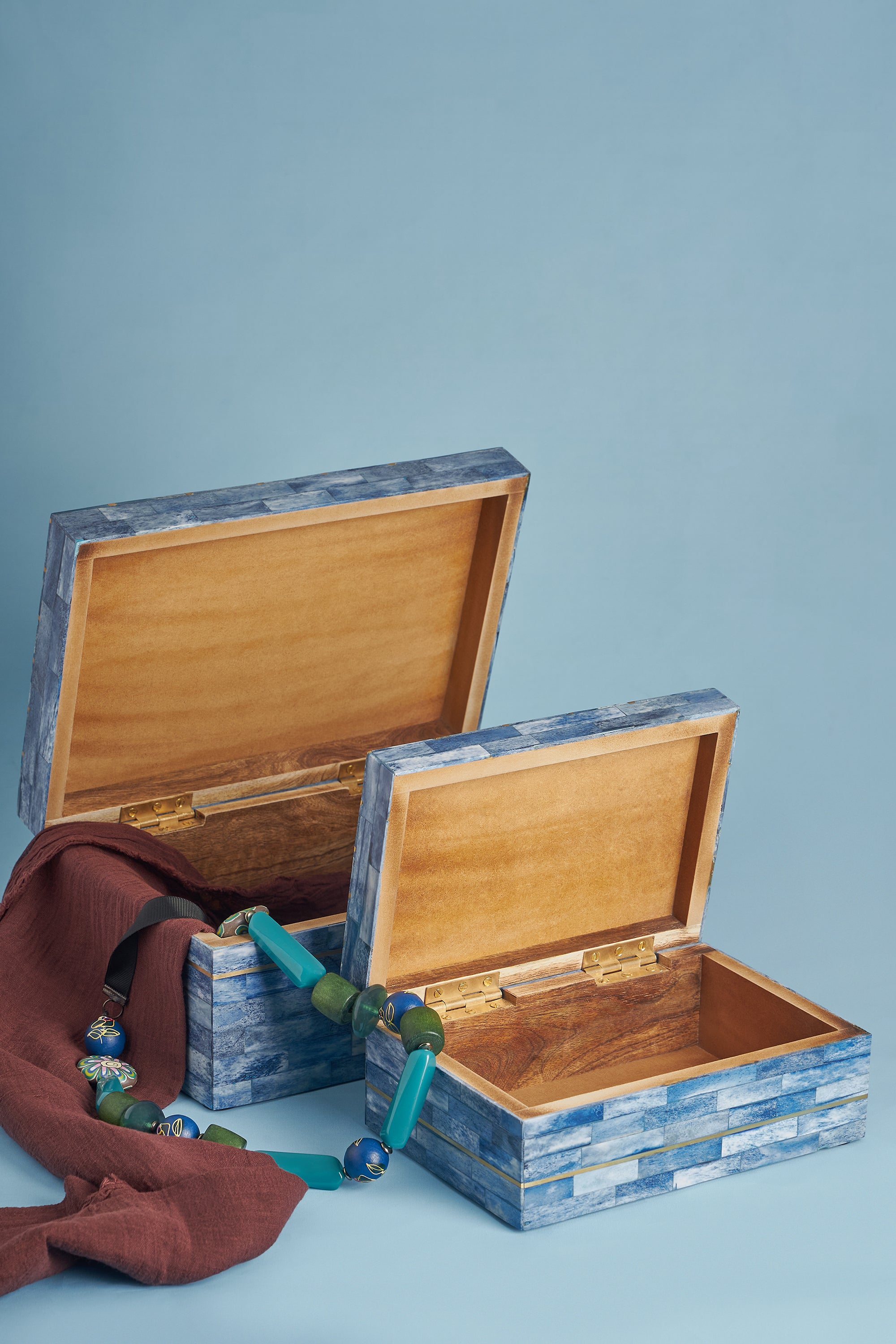 Artisan-made blue decorative boxes inspired by nautical design with gold trim — elegant home accessory