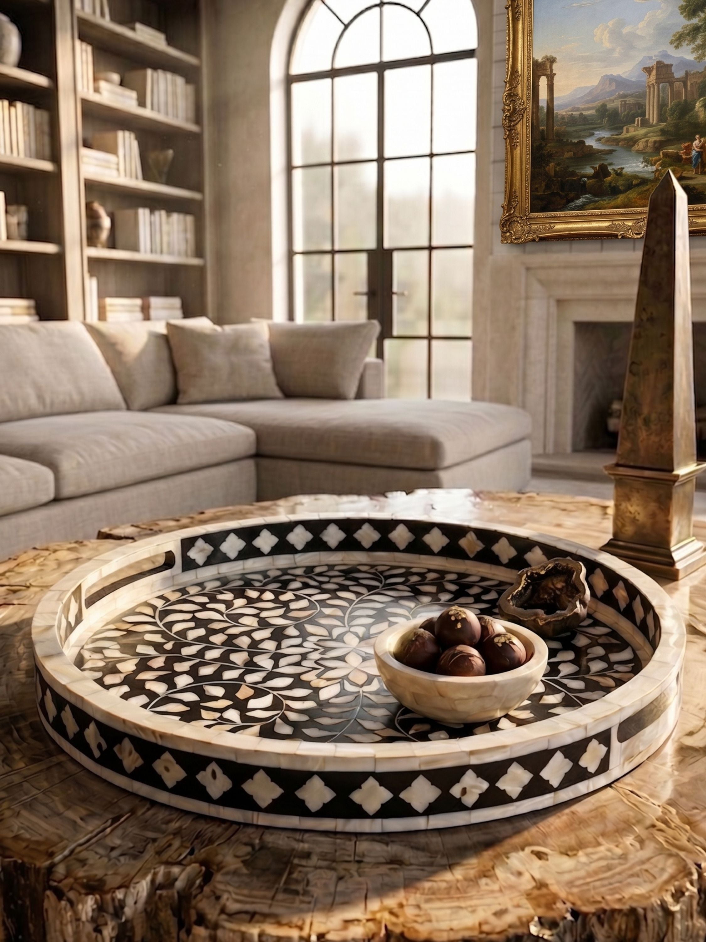 Round mother of pearl inlay decorative tray with black and ivory geometric pattern, styled on a wooden coffee table in a refined living room setting