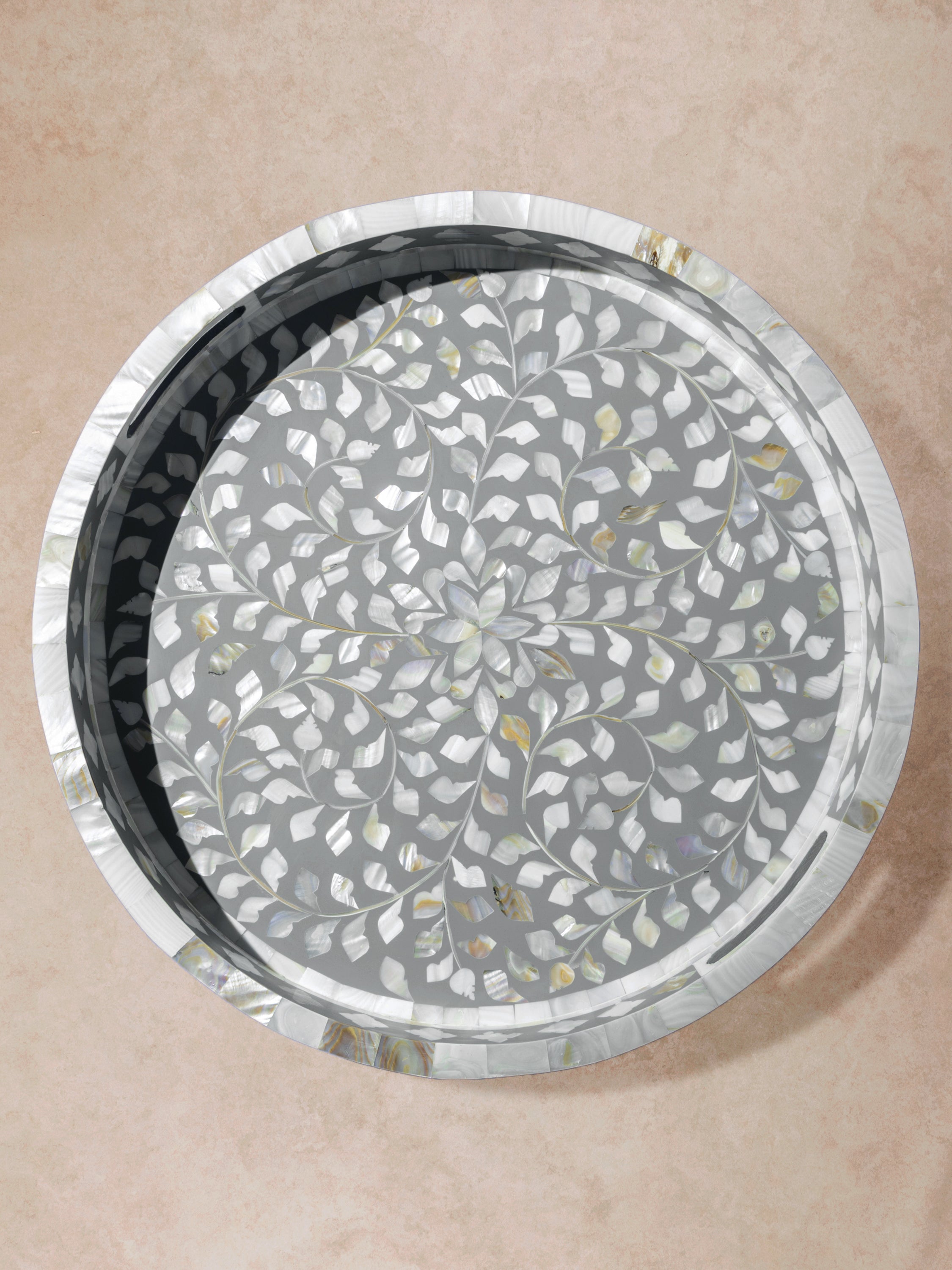 Round tray with grey ground and intricate floral vine inlay, shown in a clean overhead view