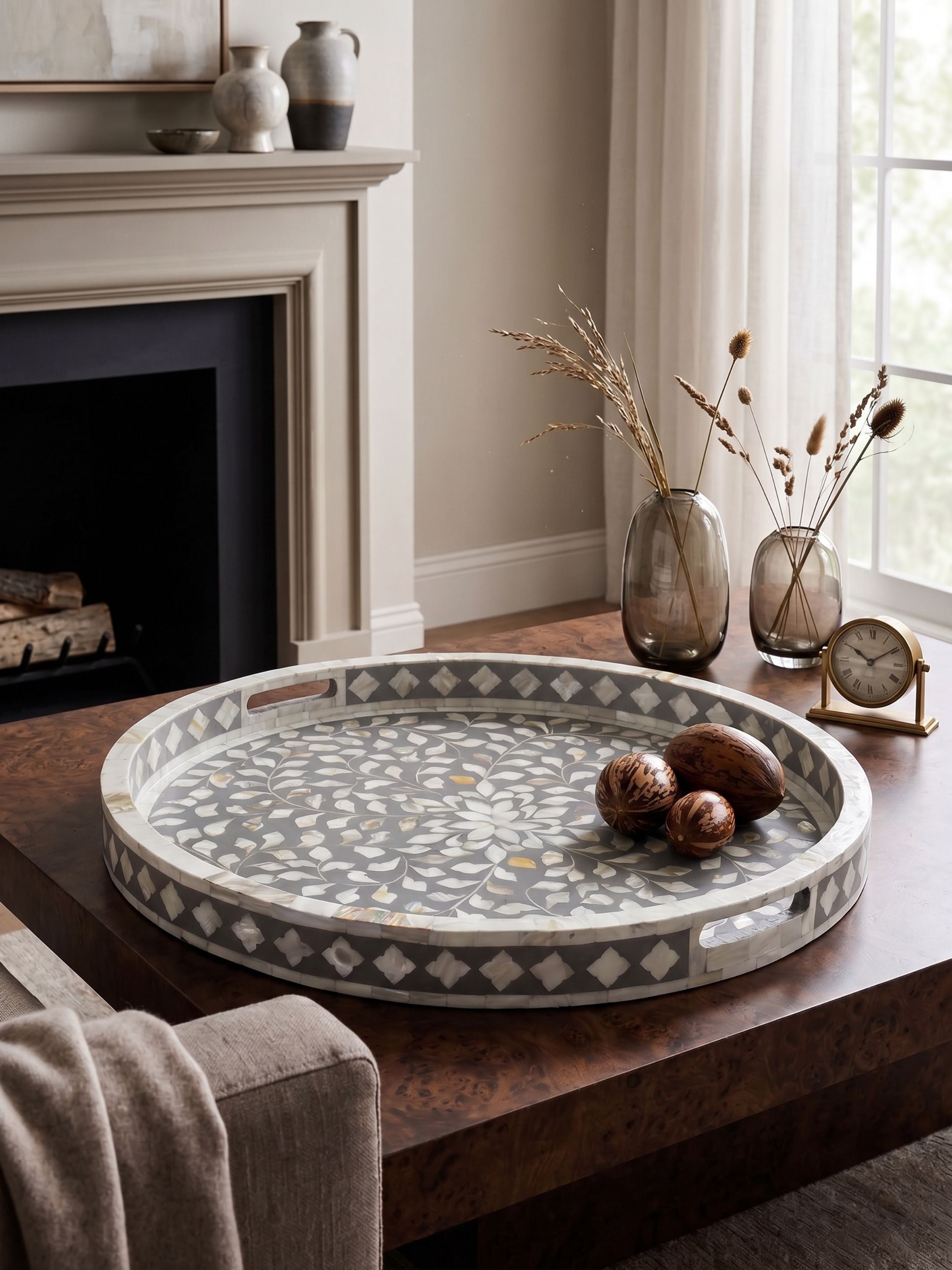 Round mother of pearl inlay tray styled as a coffee table centerpiece in a neutral living room setting