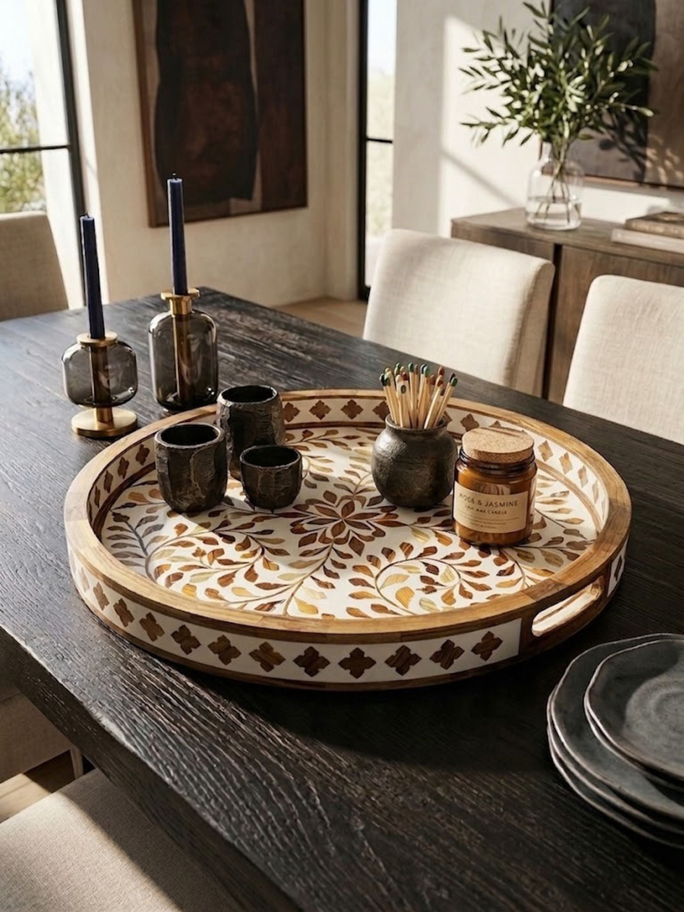 Mother of pearl inlay round tray with an amber-veined brown ground, styled on a dining table.