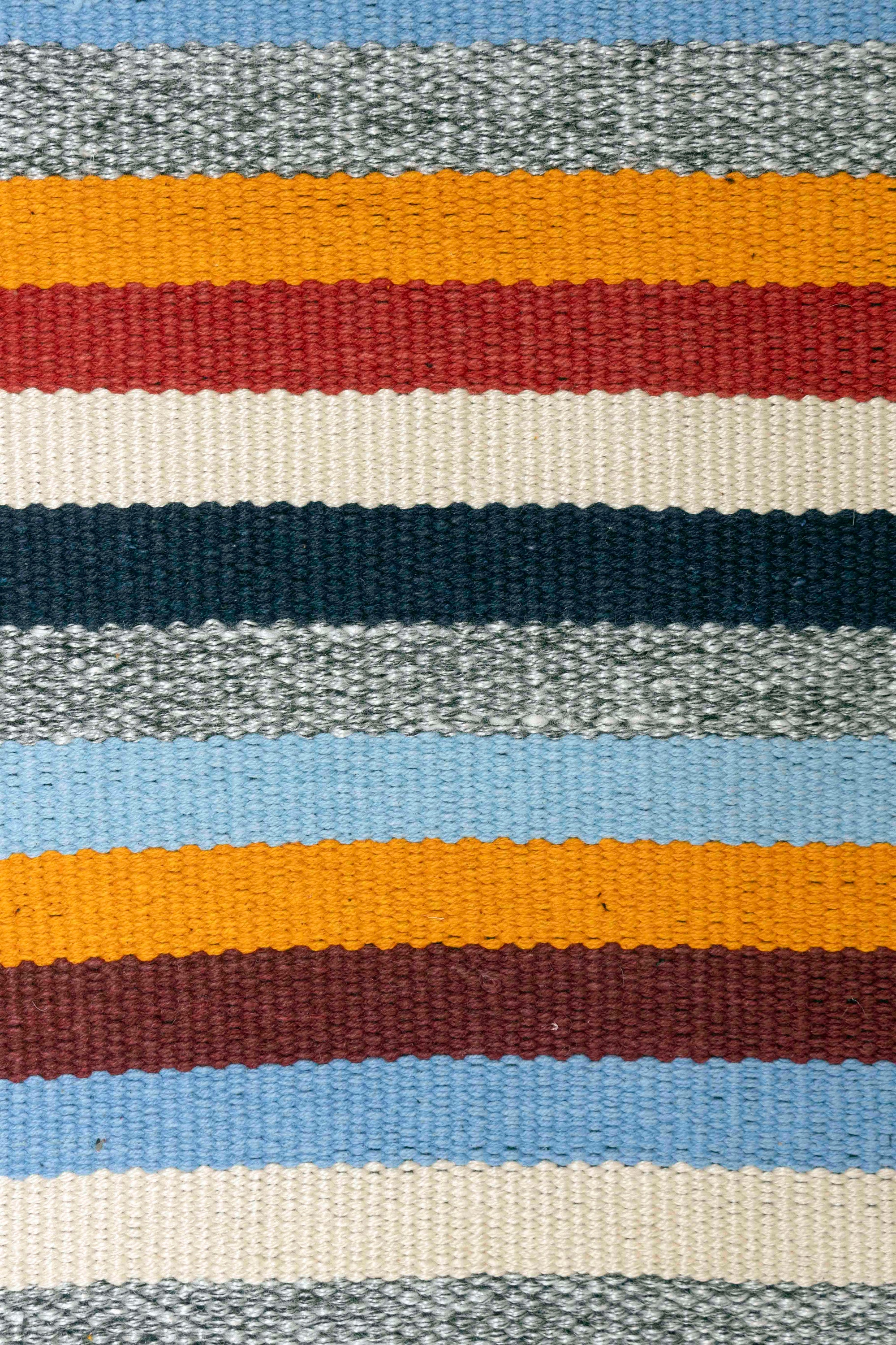 Artisan-crafted woven wall hanging featuring a mix of neutral and vibrant tones, accented with long tassel fringe
