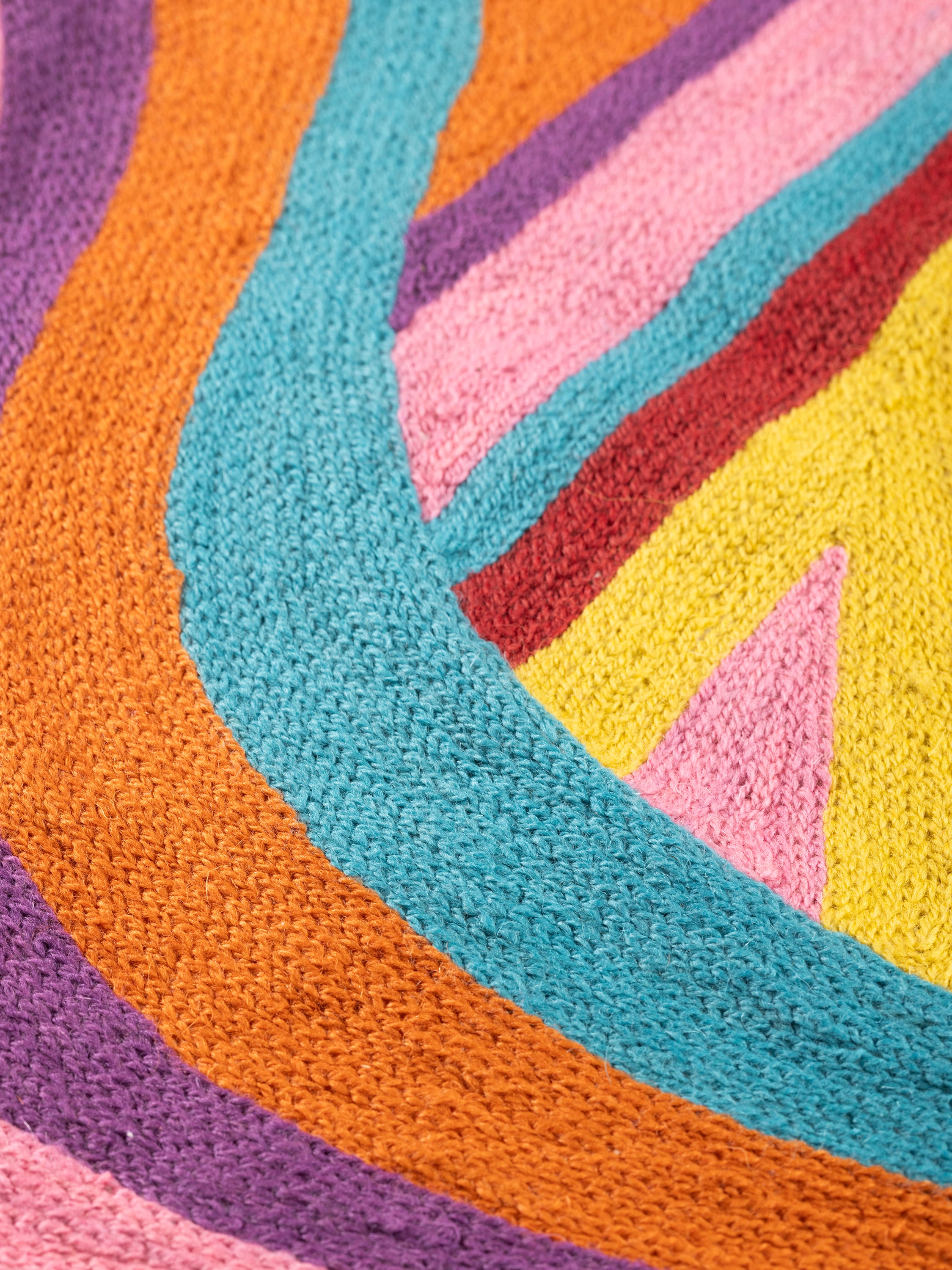 Close-up of the Ramona embroidered surface highlighting dense stitchwork, curved color transitions, and subtle texture variation.