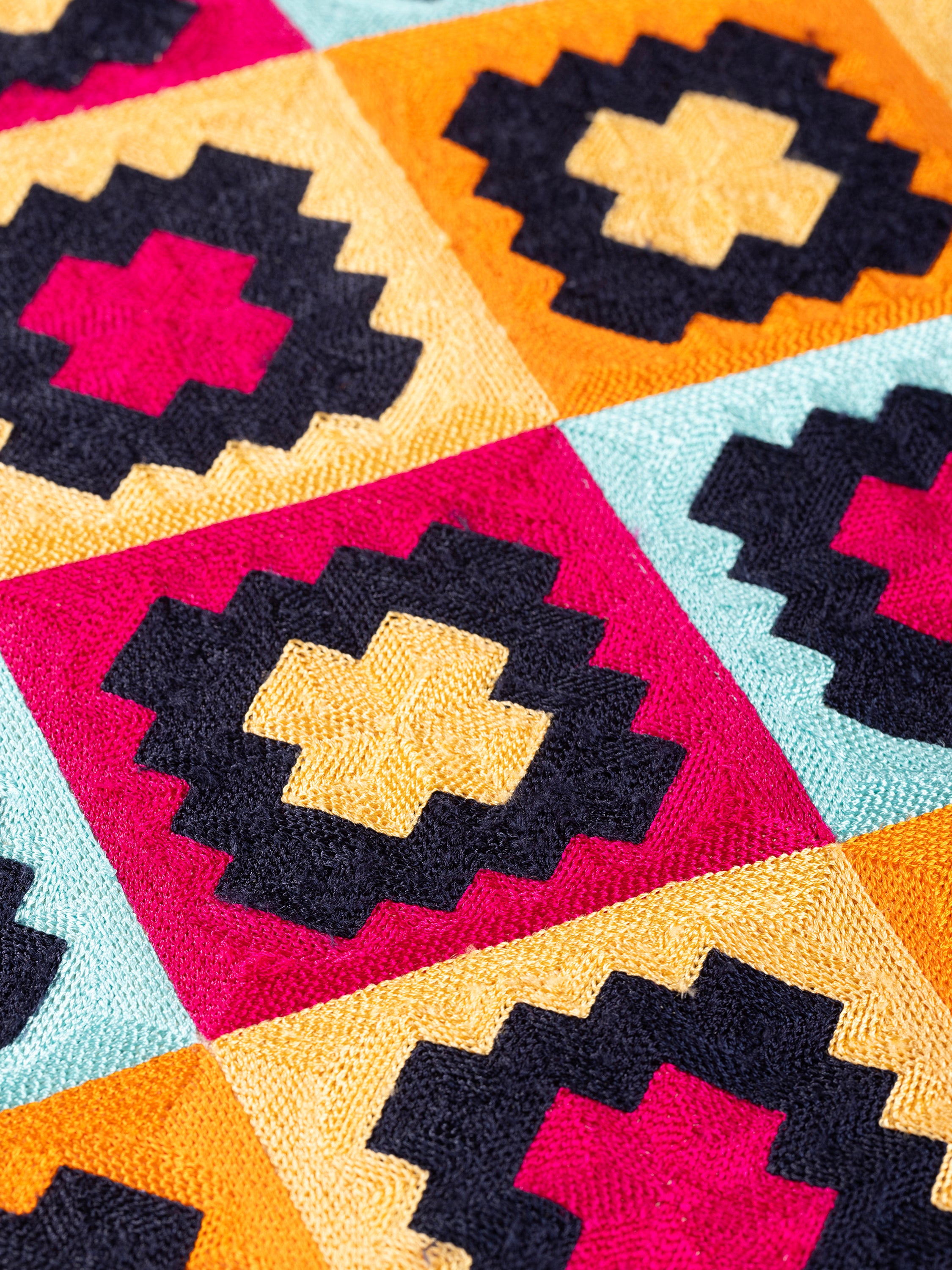 Decorative throw pillow in cotton with raised embroidery of bold geometric motifs — handcrafted design accessory