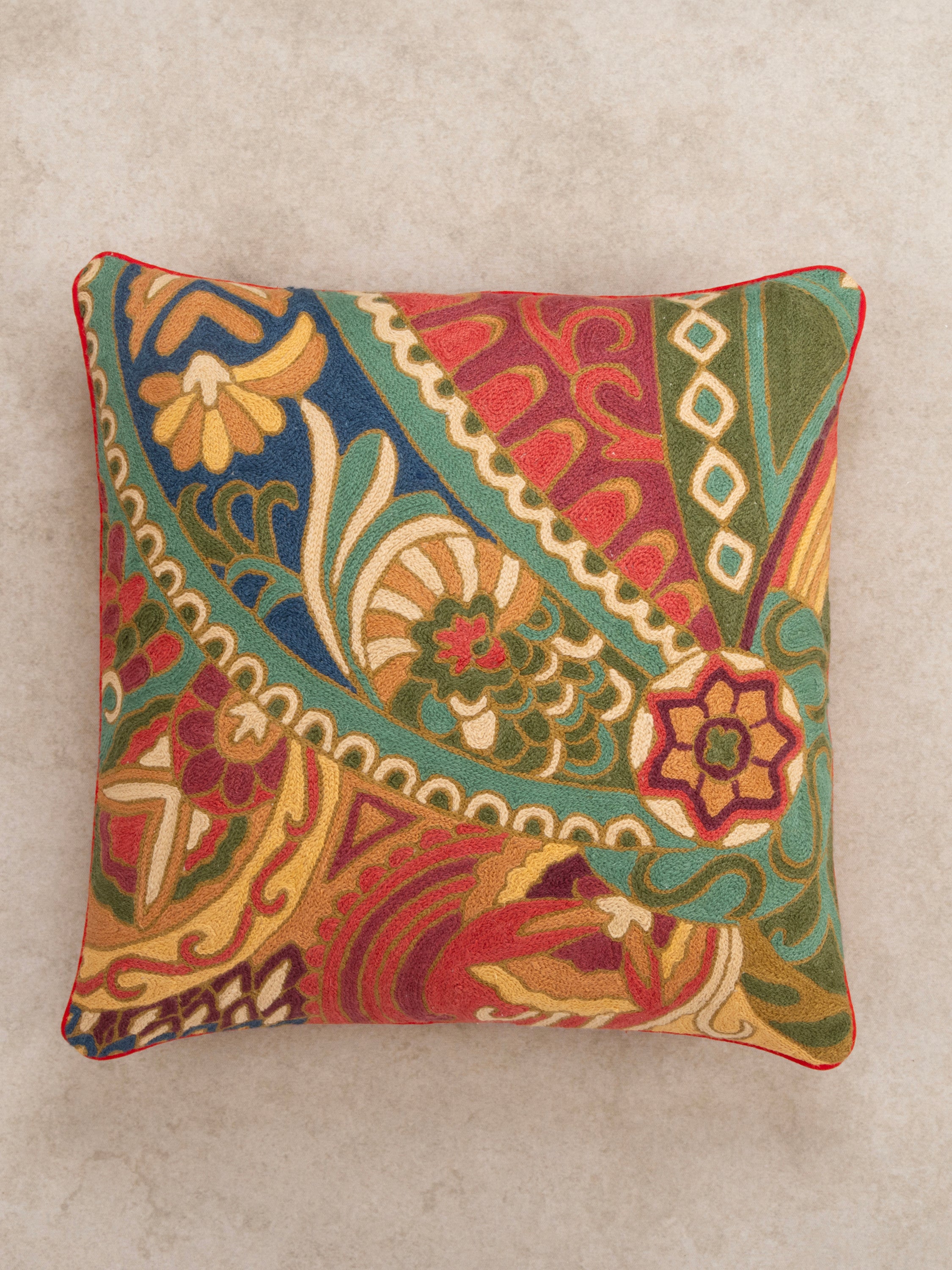 Handcrafted cushion with an ornate embroidered motif, blending traditional and modern design elements for a stylish accent