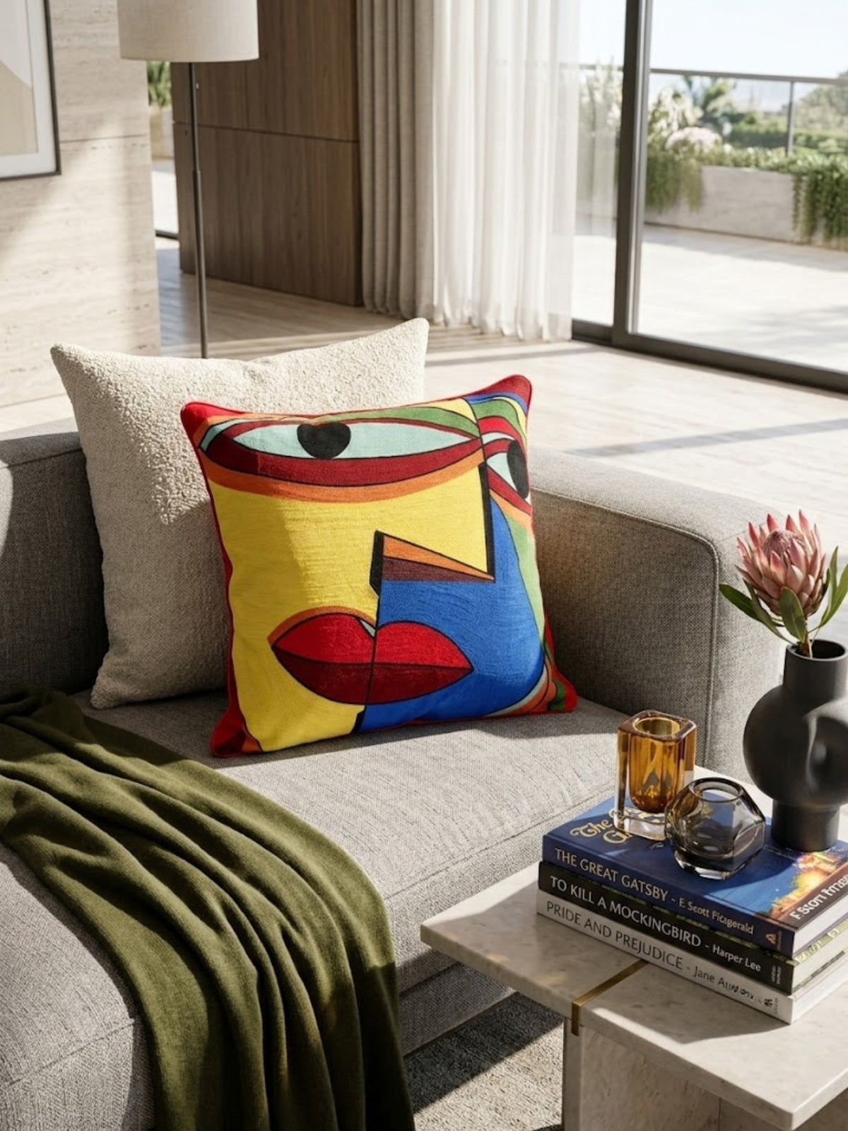Anatolia cotton pillow with embroidered color blocks, on a cream sofa beside an olive throw.