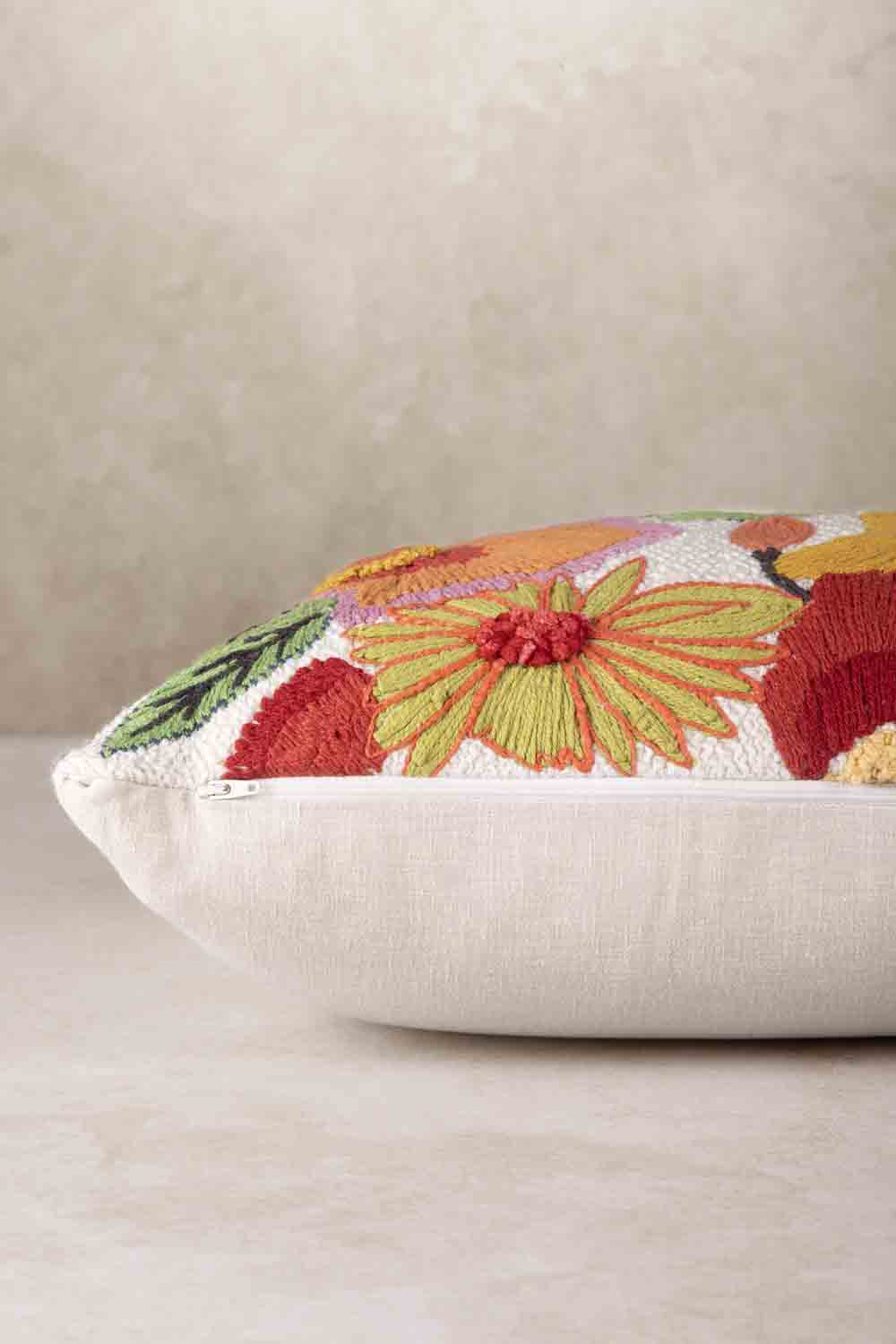 Side profile of rectangular throw pillow showing plush filled structure, soft rounded edges, and contrast between embroidered front and smooth cotton backing