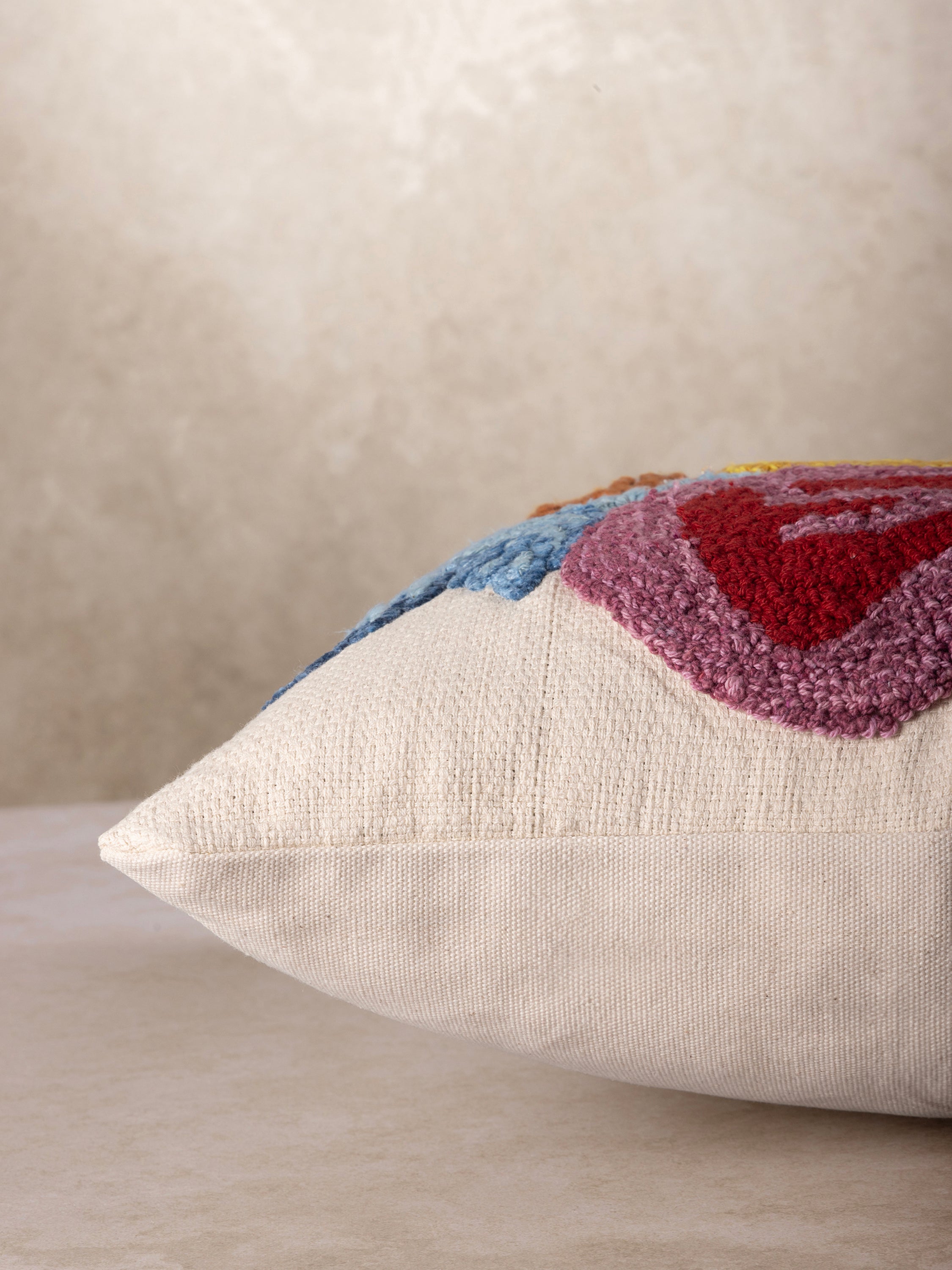 Artisan-made throw pillow with multicolored tufted florals and embroidered detail on soft cotton — luxury home layer