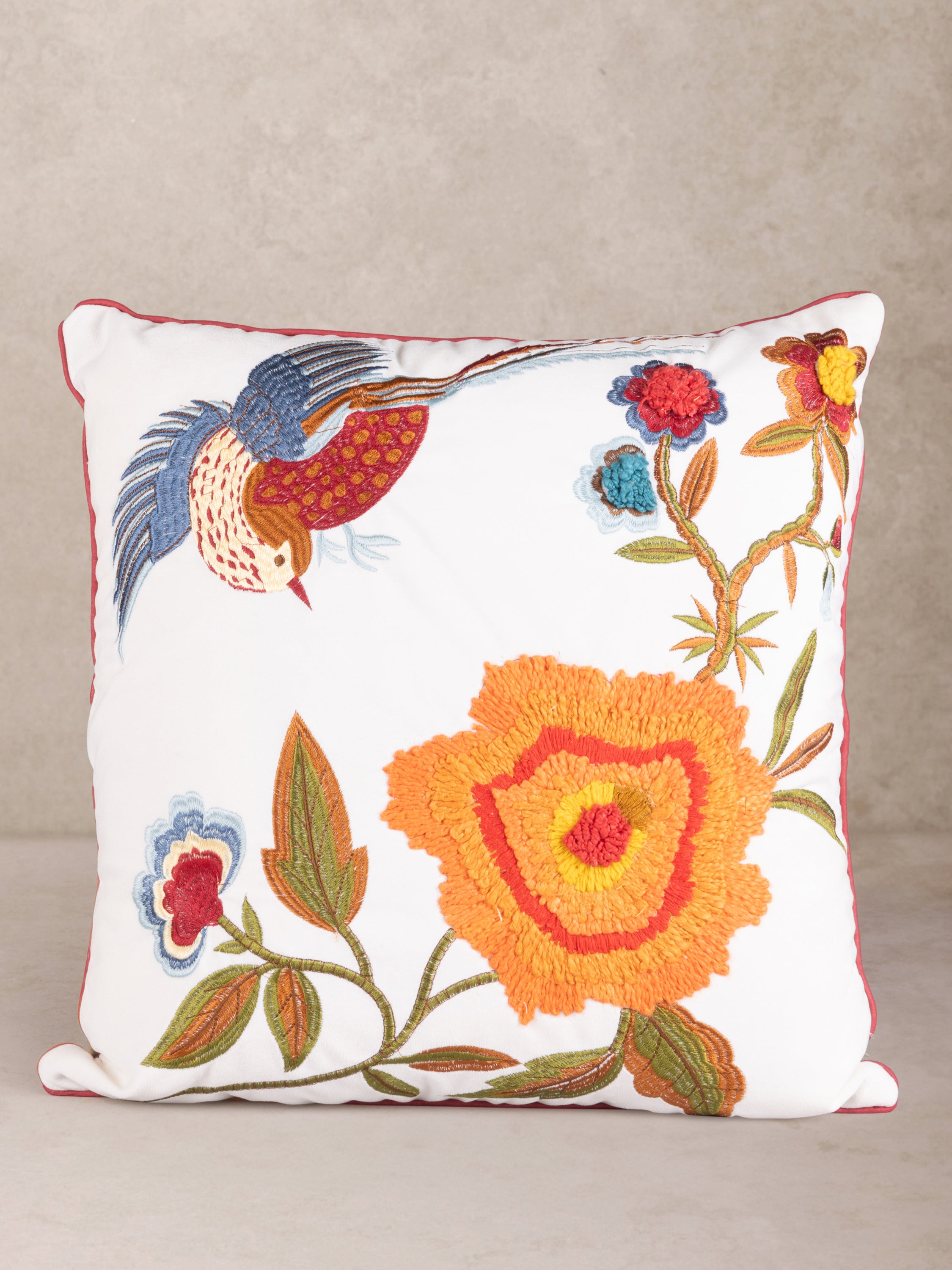 Handcrafted cotton throw pillow with embroidered bird and bold floral motifs in multicolor — artisan luxury accent