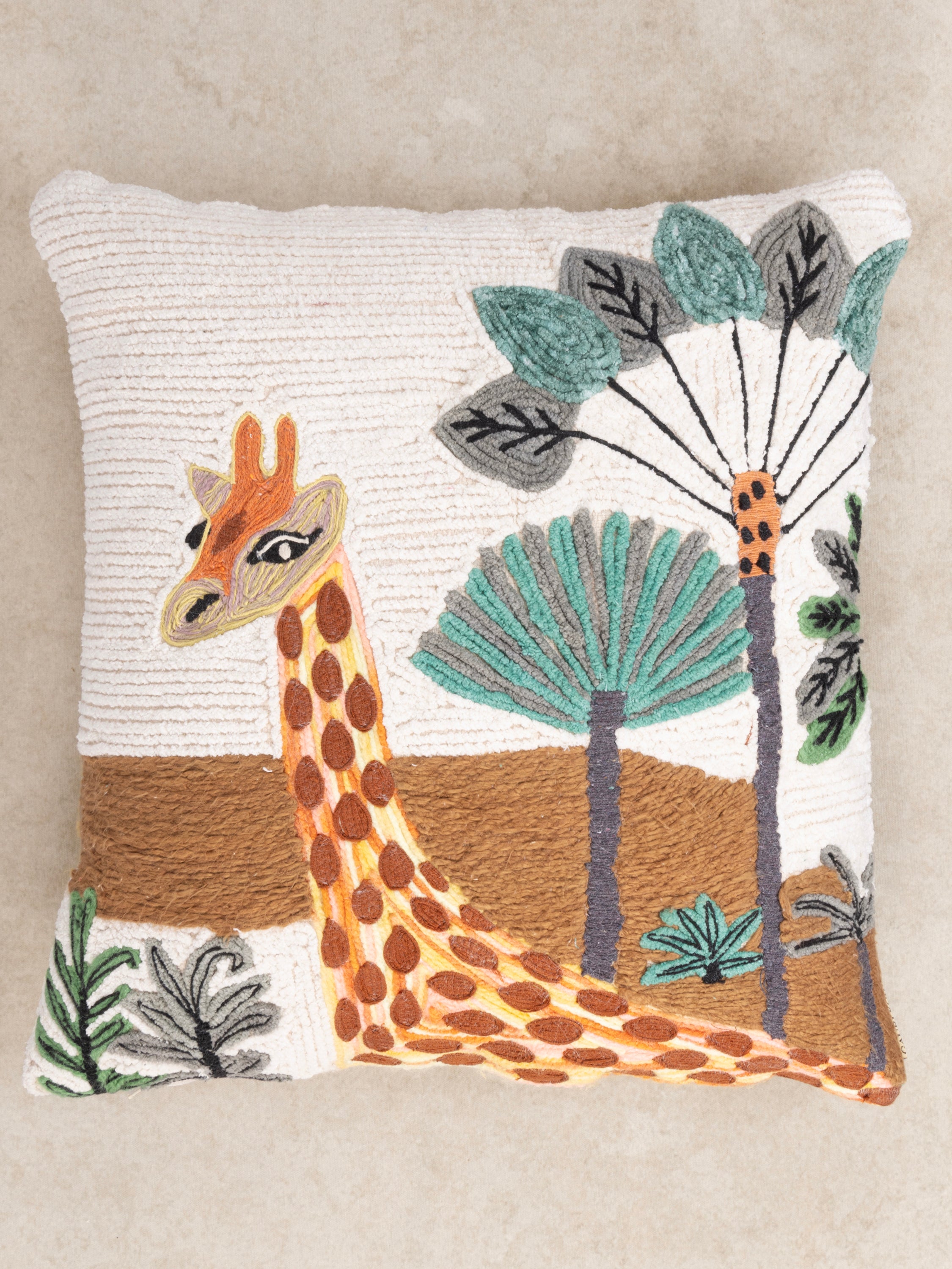 Decorative 20″×20″ pillow in natural cotton featuring raised wildlife embroidery and botanical textures — refined home décor piece