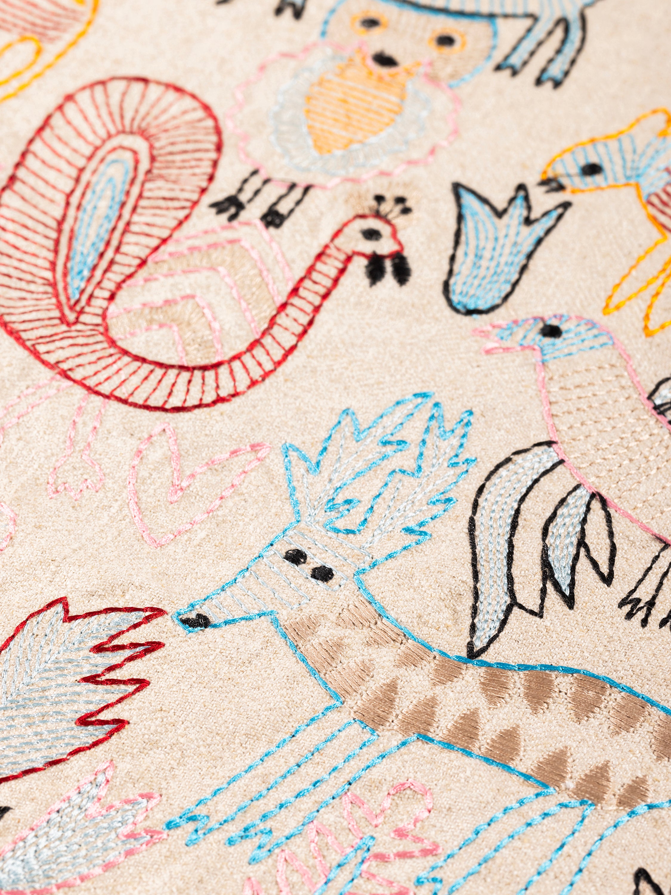 Decorative throw pillow with raised embroidery of animals and foliage on soft cotton — handcrafted design accessory