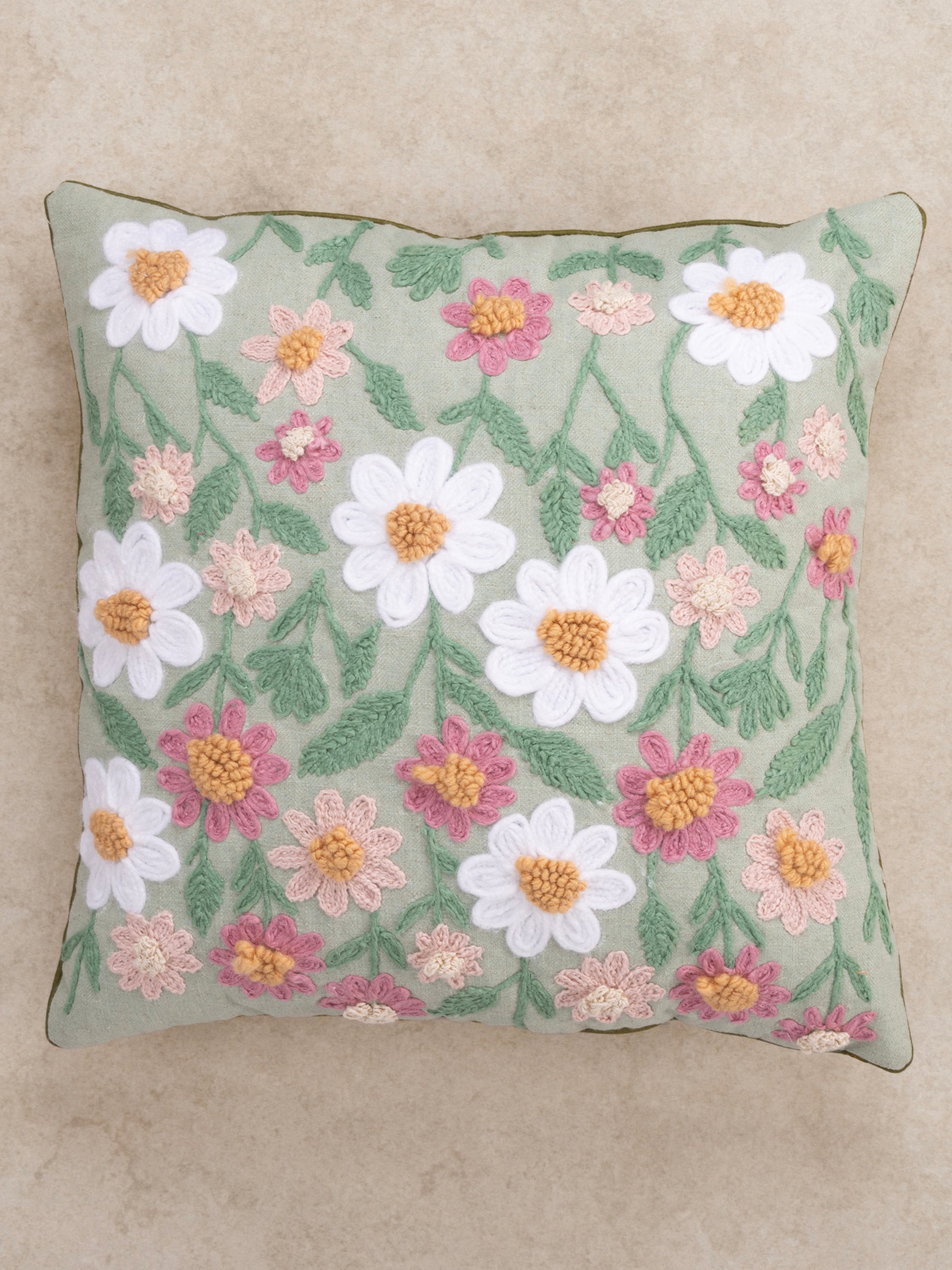 Textured floral pillow 20″×20″ in natural cotton with raised daisy embroidery and muted green tone — refined home décor piece
