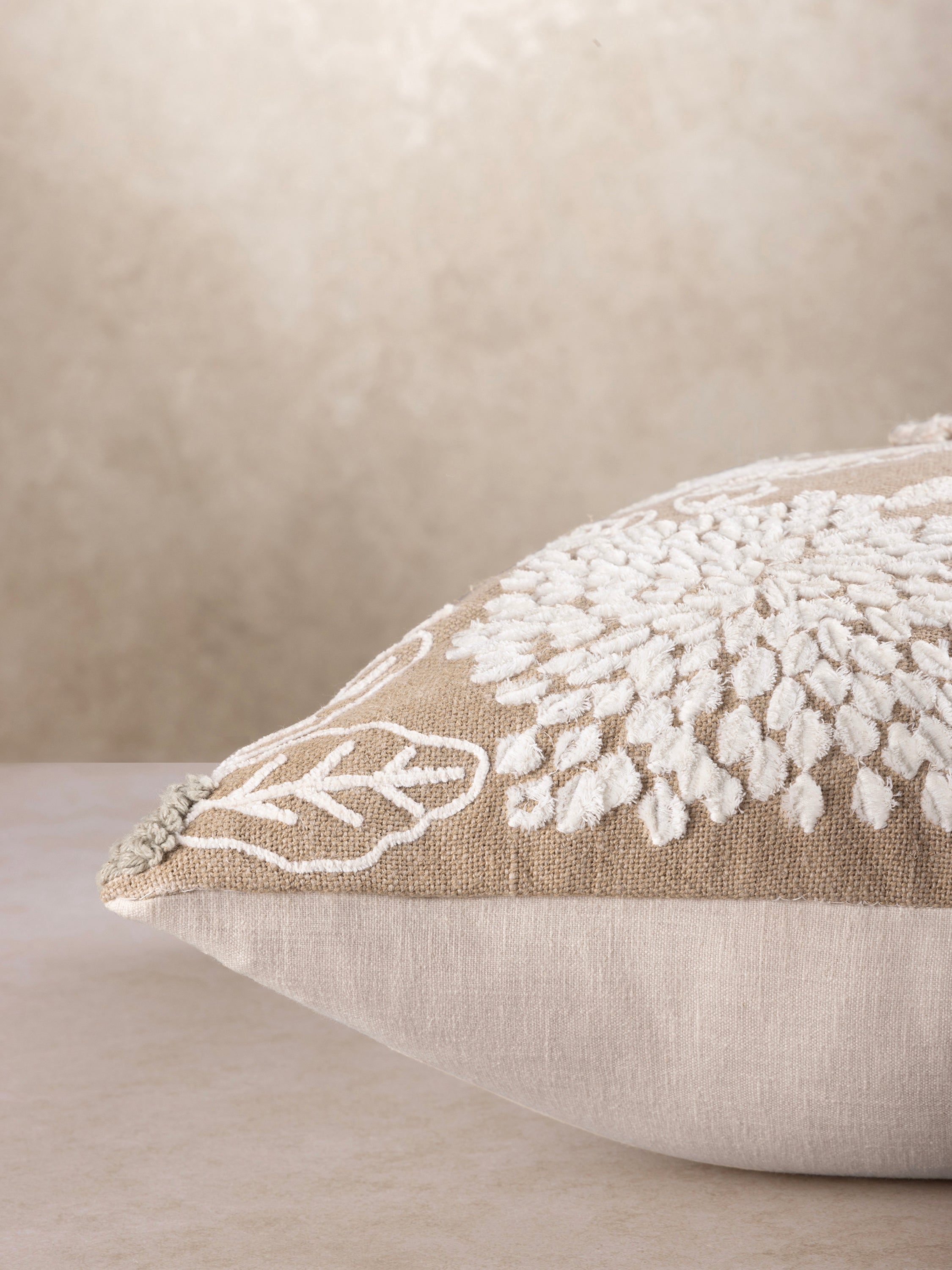 Artisan‑made decorative pillow in cotton with raised tufted floral texture and embroidered accents — luxury home layer