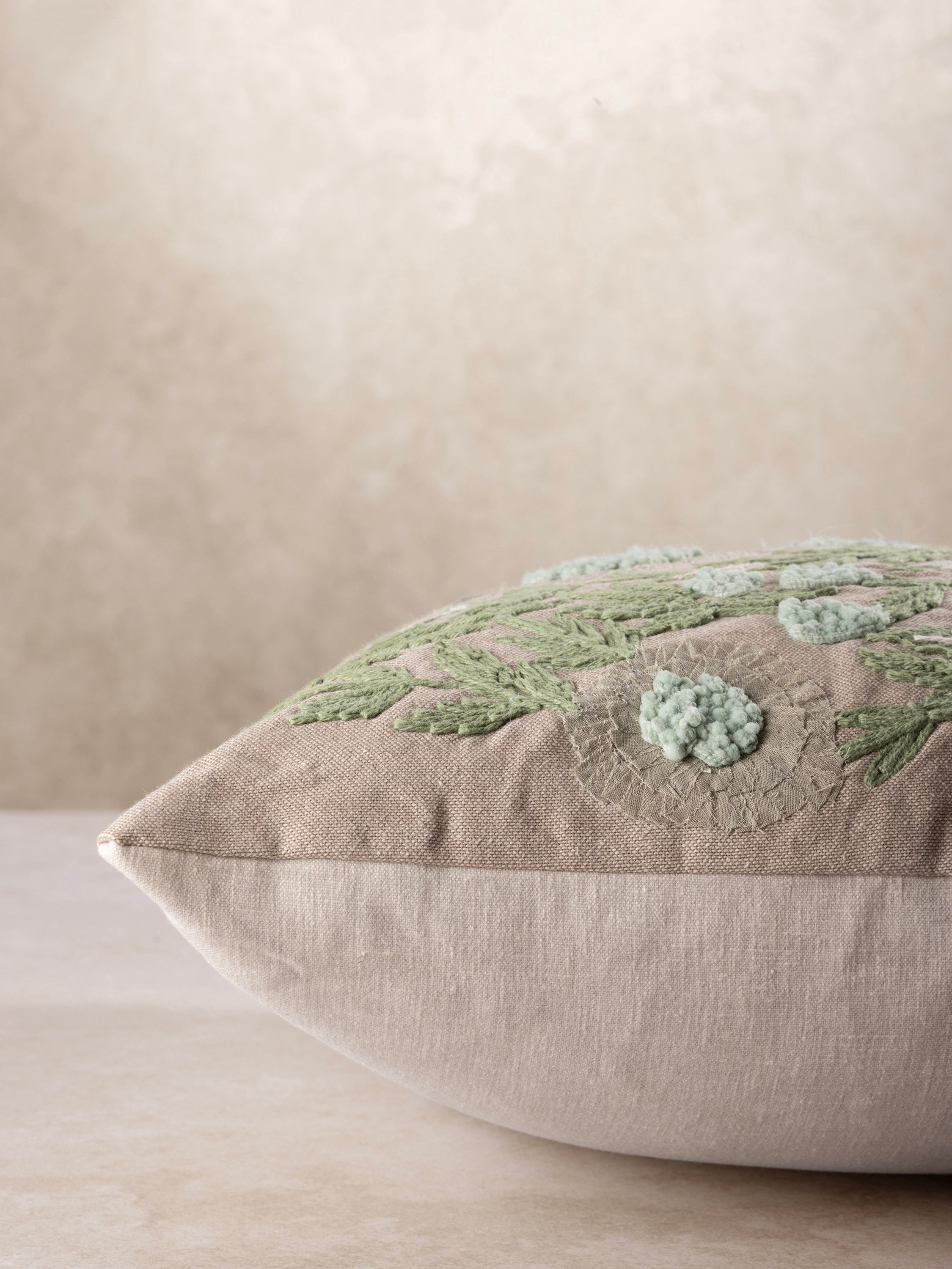 Artisan-made cotton pillow featuring raised botanical stitchwork and soft neutral palette — luxury home layer