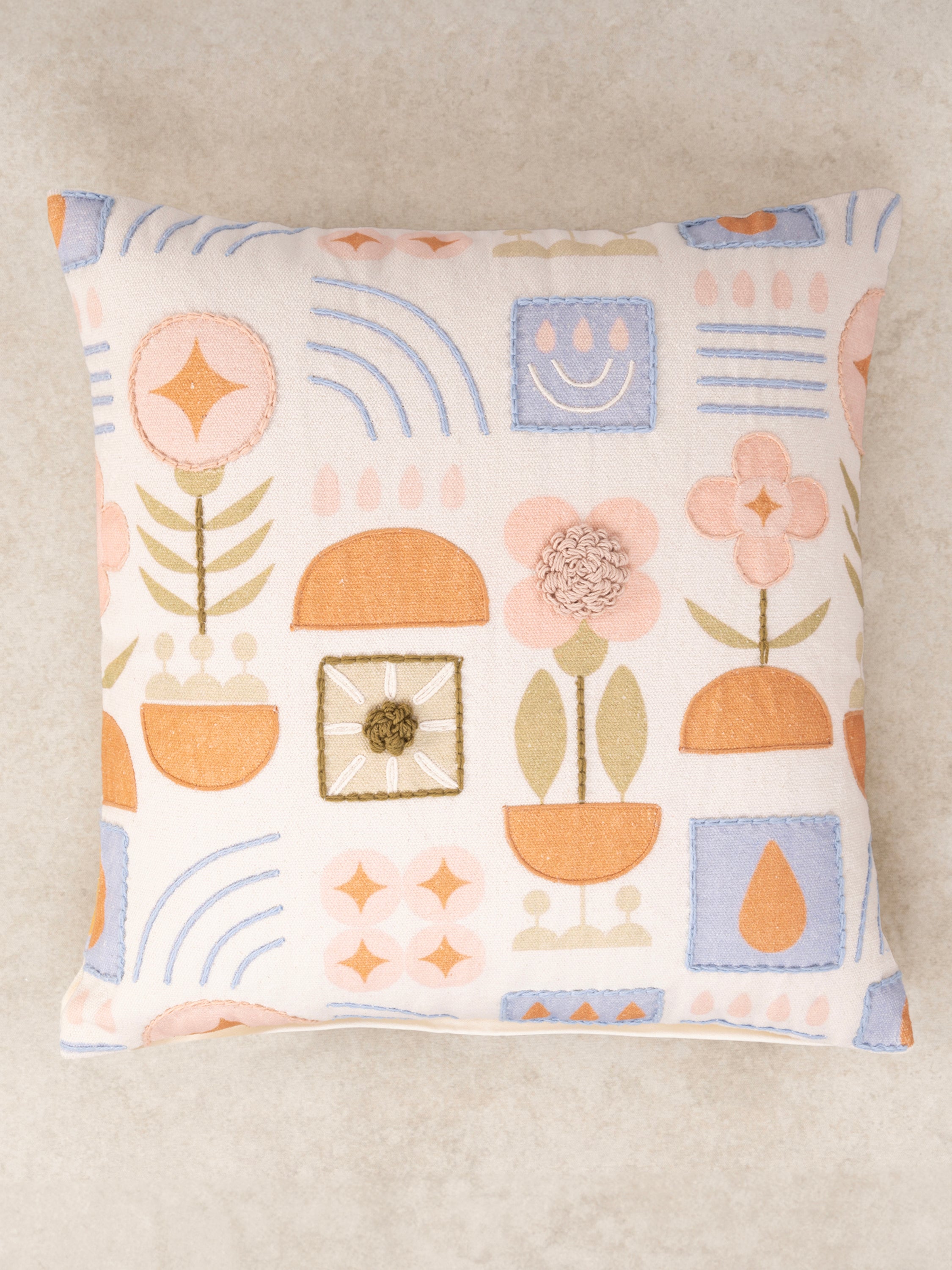 Decorative 20″×20″ pillow combining print and hand stitch on natural cotton — refined artisan décor piece