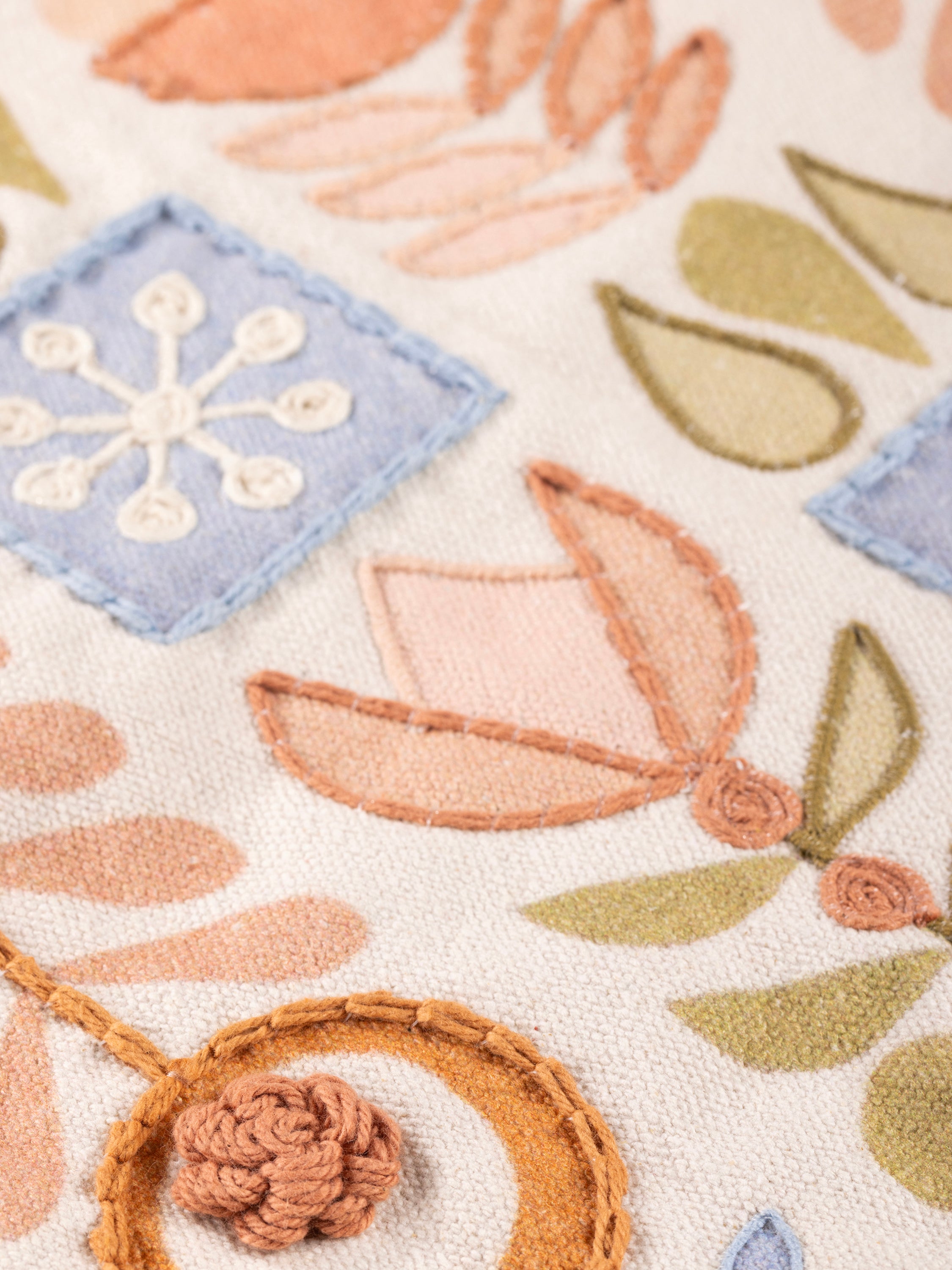 Textured cotton throw pillow with subtle pastel embroidery and raised detail — handcrafted design accessory