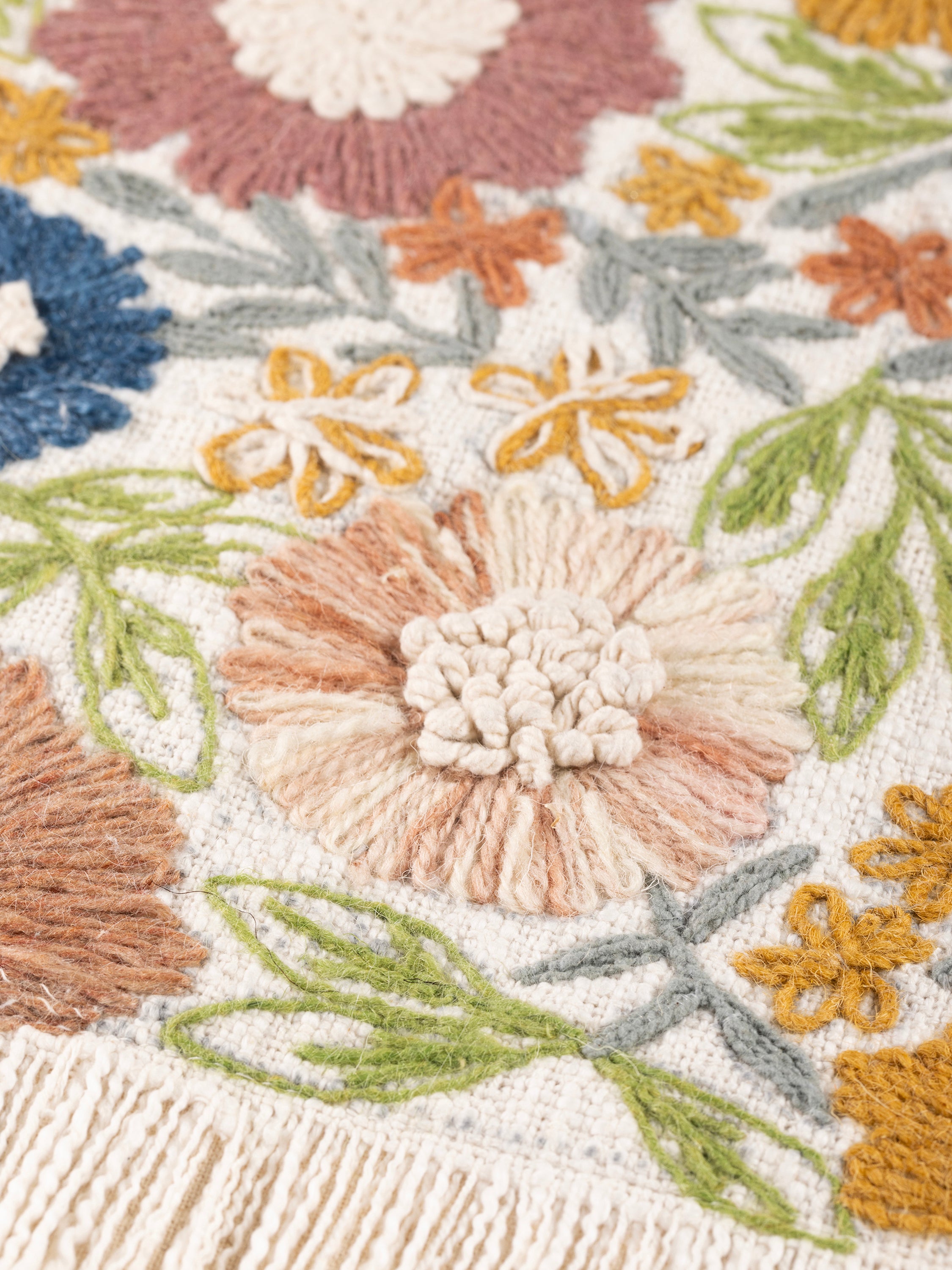 Close-up of the Perth embroidered surface highlighting floral stitchwork, soft color variation, and fringe edge detailing.