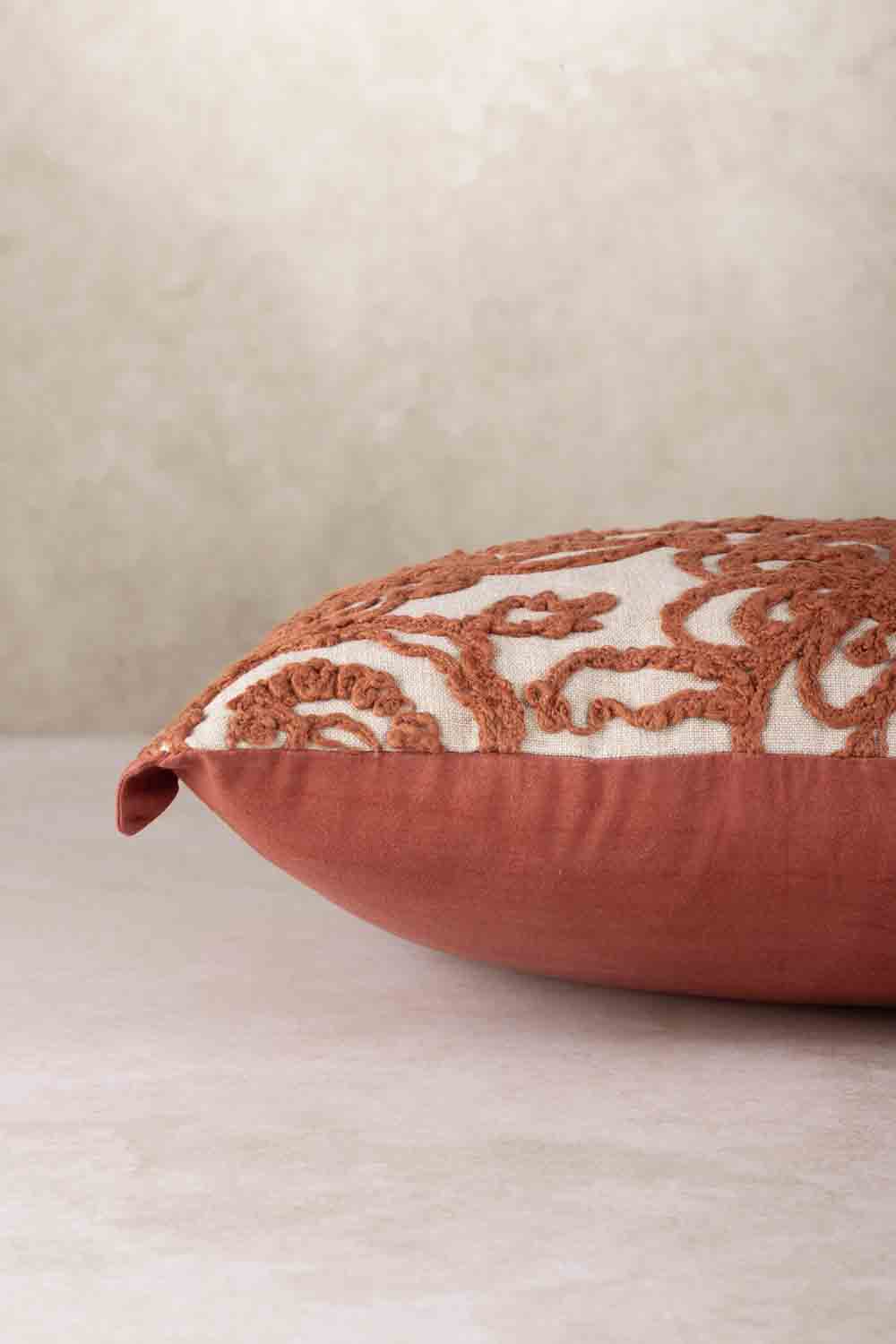 Side profile of rectangular throw pillow showing plush filled structure, rounded edges, and contrast between embroidered front and solid backing