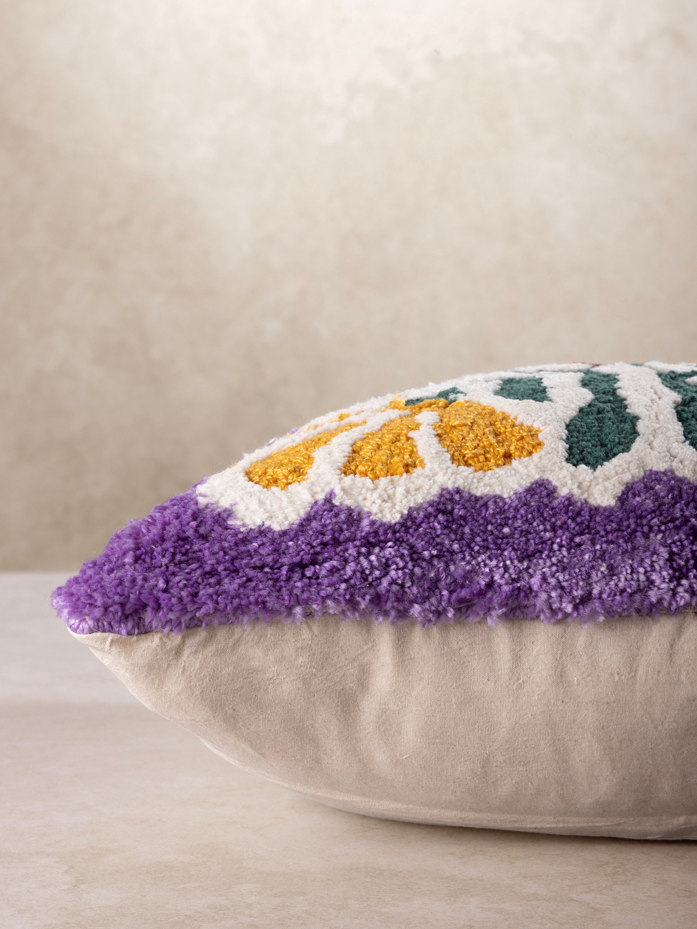 Side profile of square throw pillow showing plush filled structure, rounded edges, and dense raised textile surface with visible woven backing