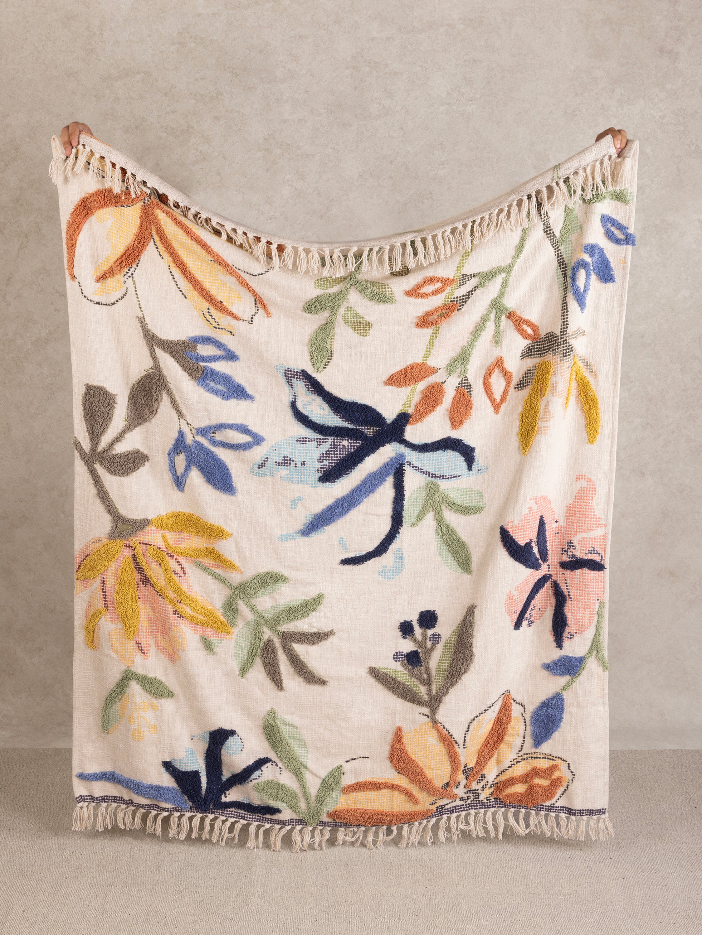 Handwoven natural cotton throw with tufted floral motifs and fringe detailing — artisan luxury textile