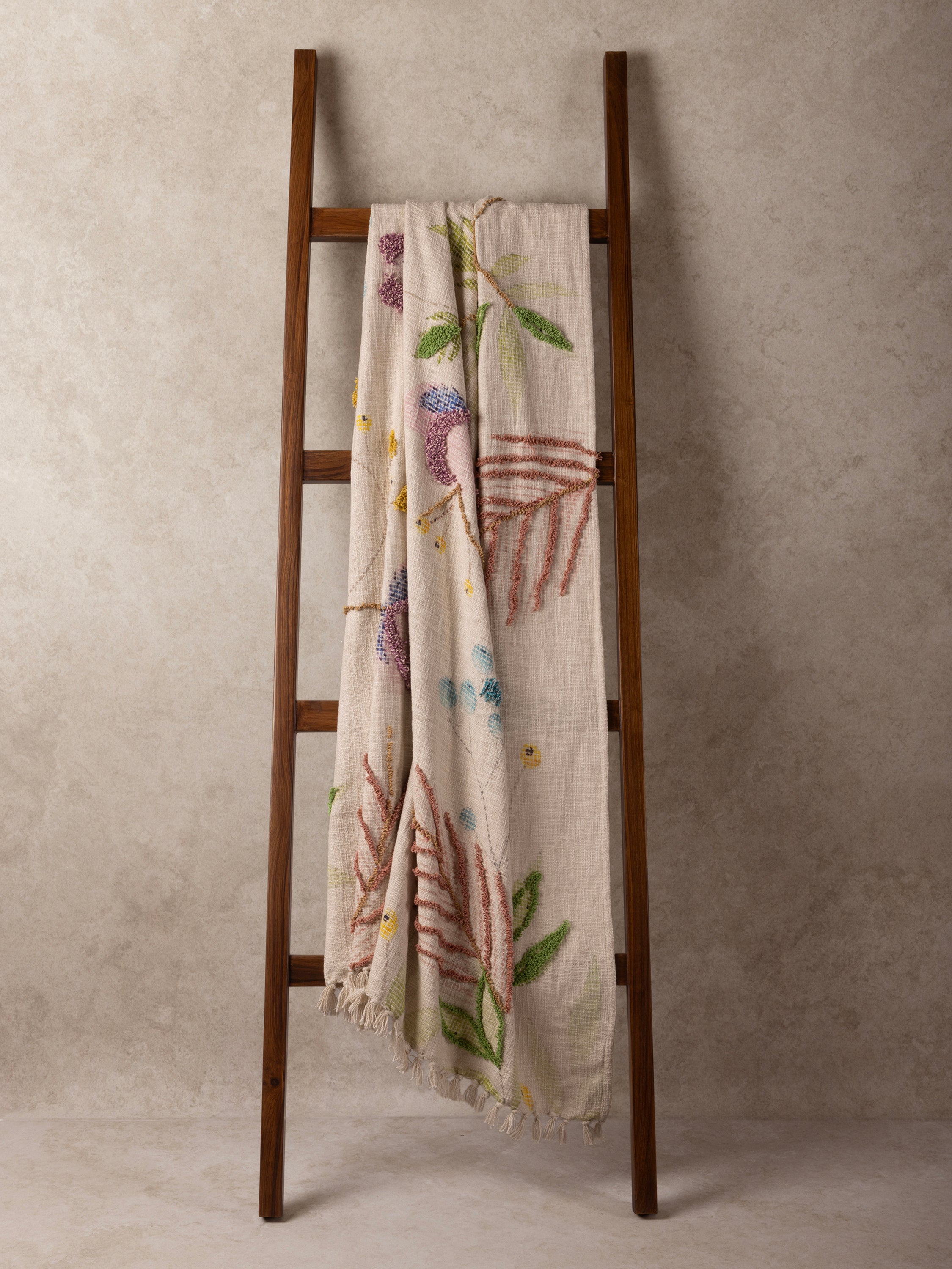 Soft canopy of floral motifs on a textured throw blanket with fringe — refined home accent