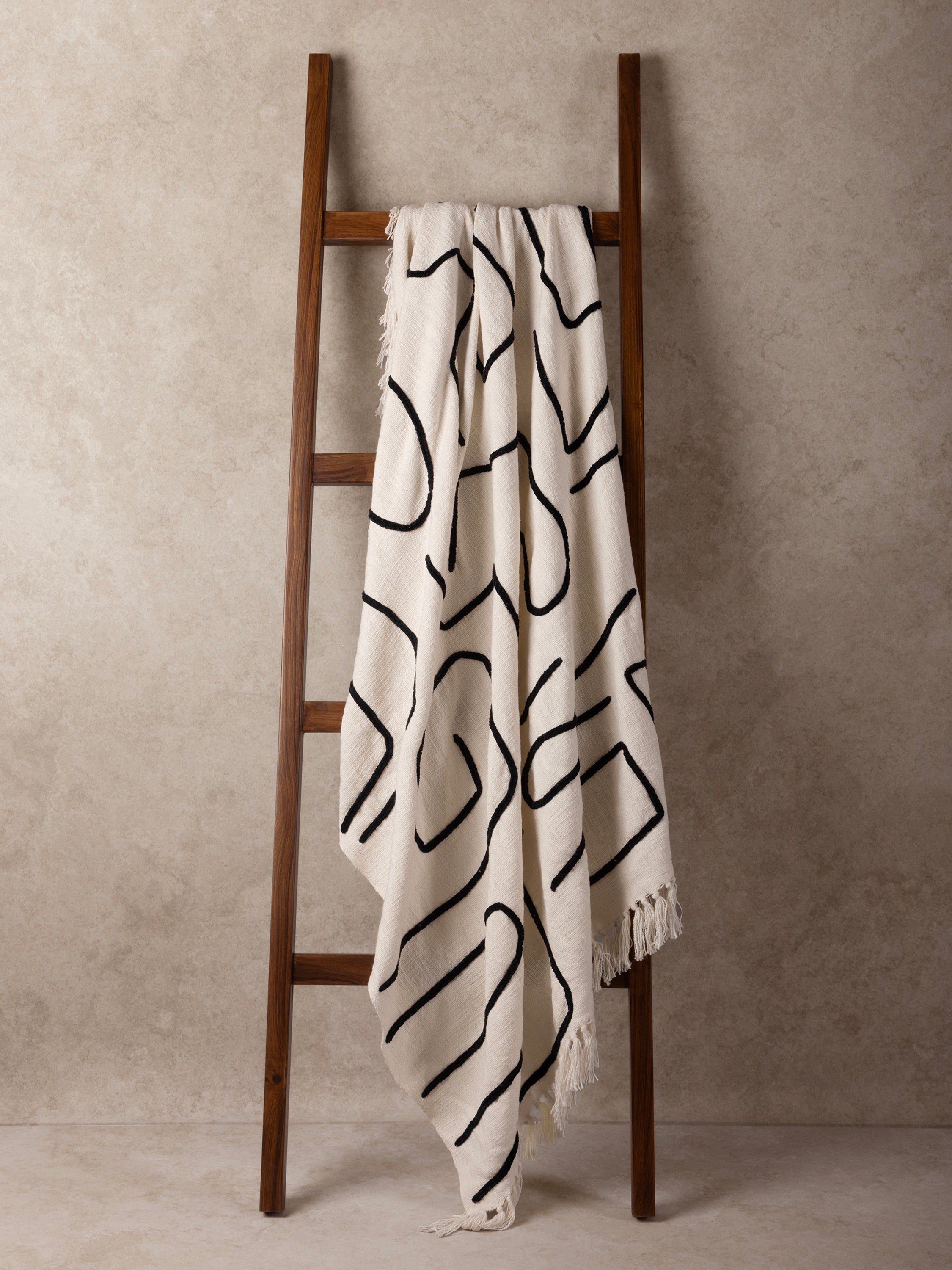 Artisan cotton throw with expressive abstract motifs and fringed edges — refined modern décor