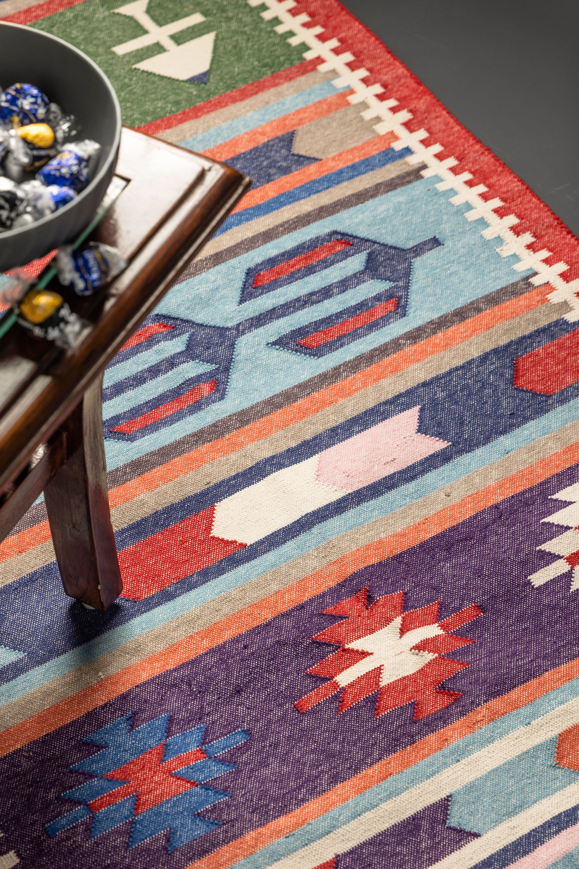 Handwoven Kilim runner rug with vibrant tribal patterns and a bold red border