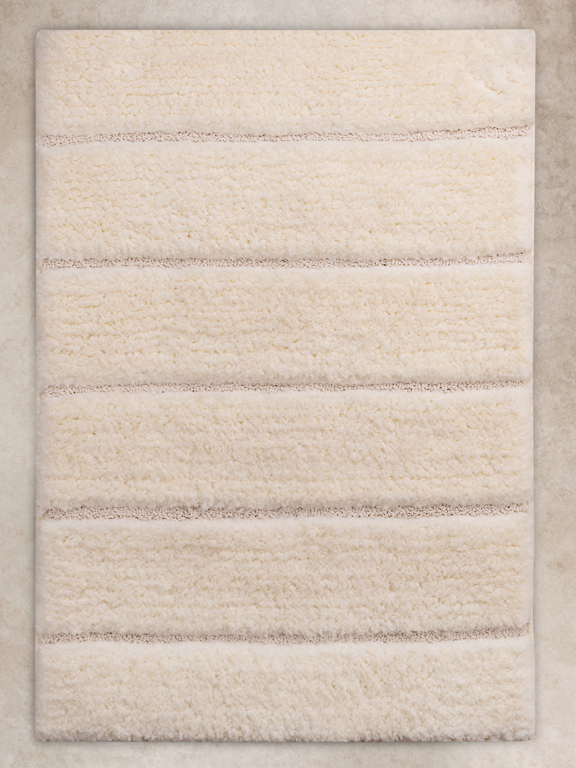 Elegant ivory bath mat with a soft, plush texture and subtle striped design