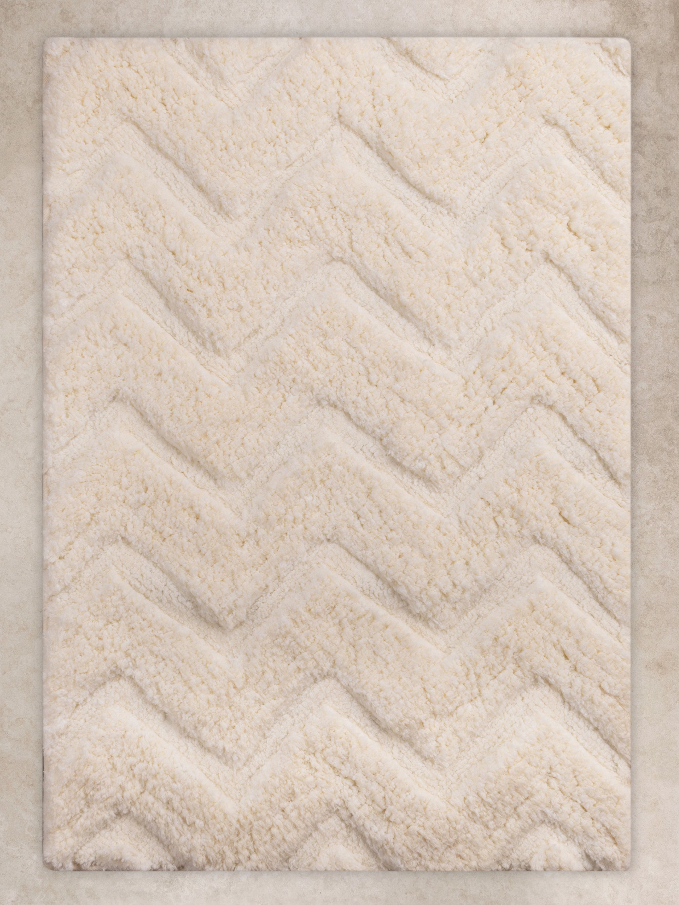 Luxury plush bath mat in ivory with a textured chevron pattern, soft and absorbent