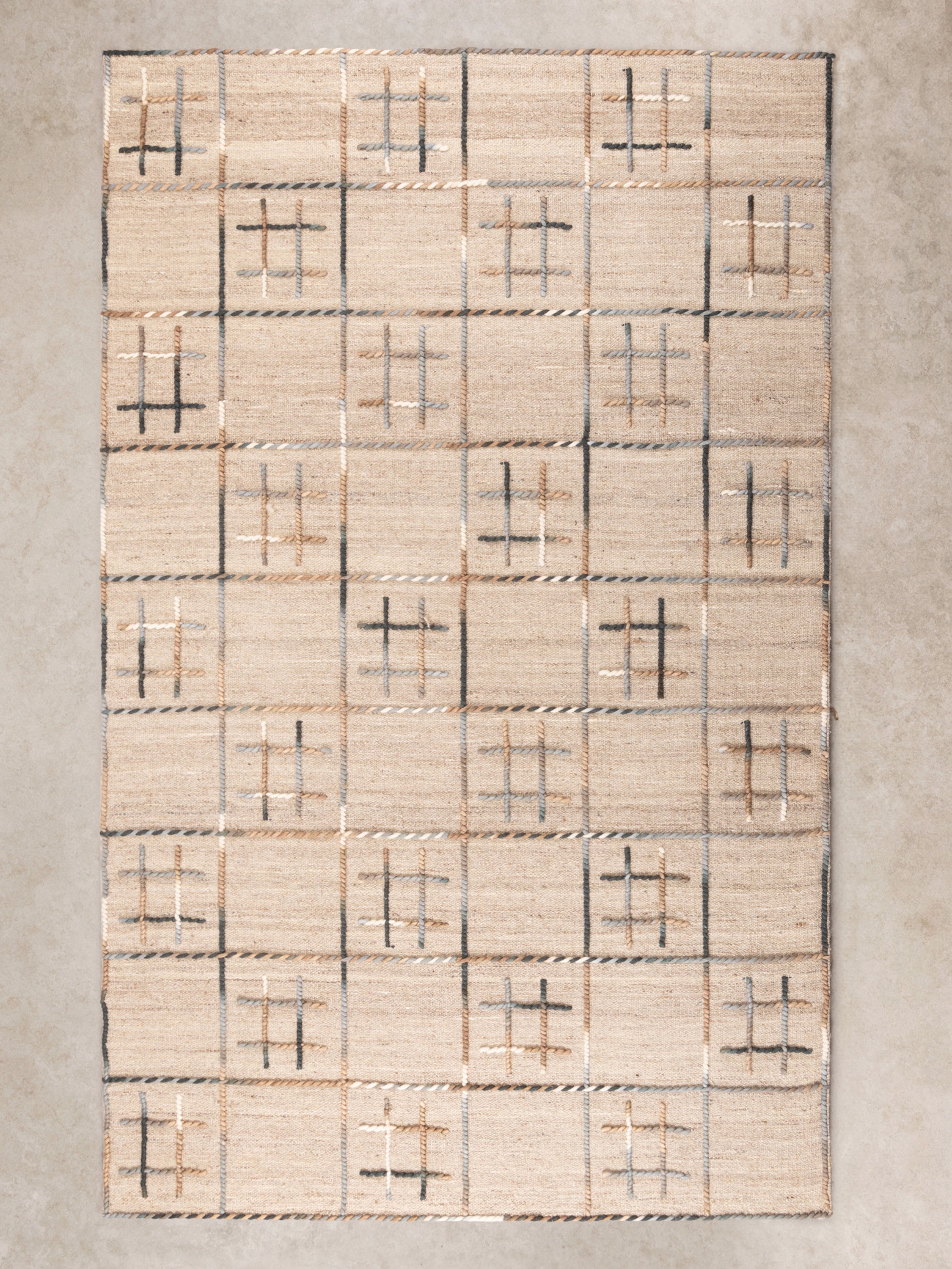 Handwoven wool area rug with a modern checkered pattern, featuring neutral tones for a minimalist home decor