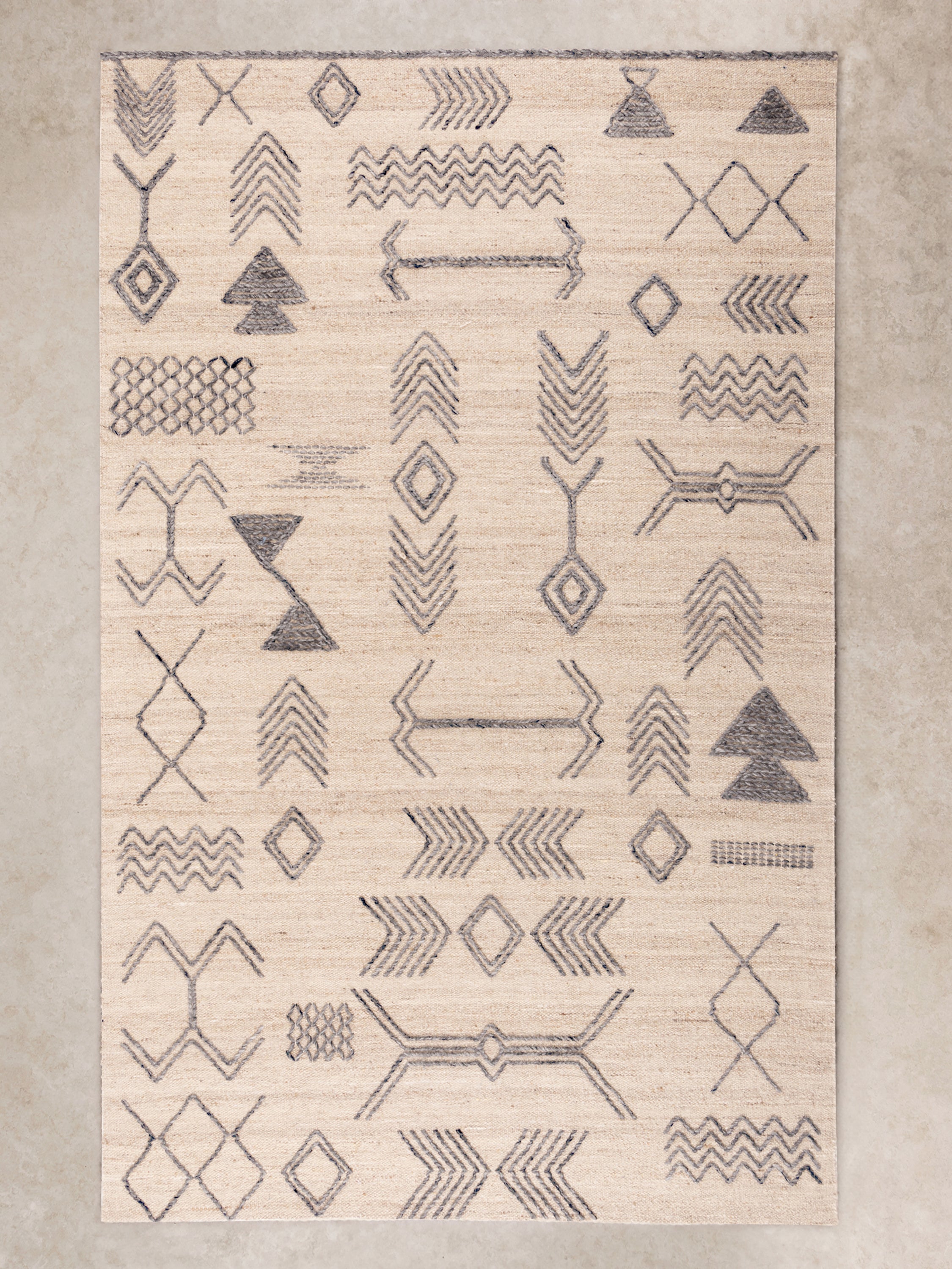 Handwoven wool area rug with tribal-inspired geometric patterns in neutral tones, perfect for modern interiors