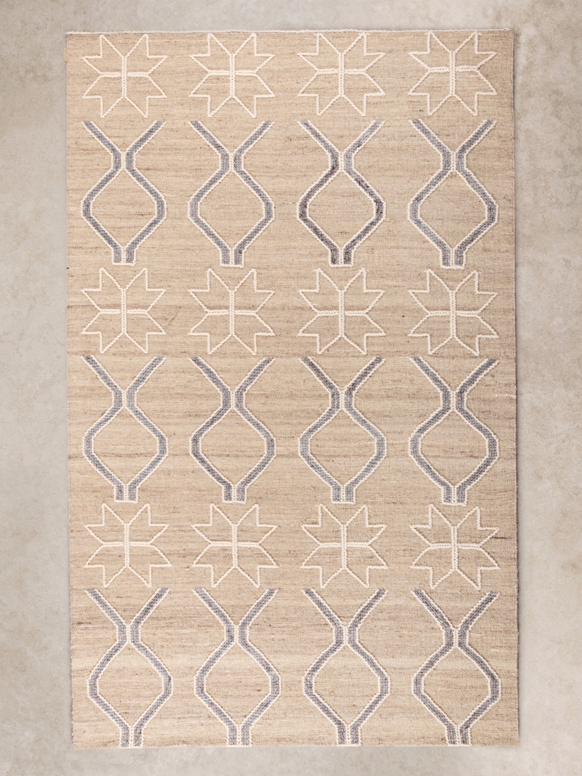 Handwoven Isaa area rug 5×8 in neutral tones under living room furniture
