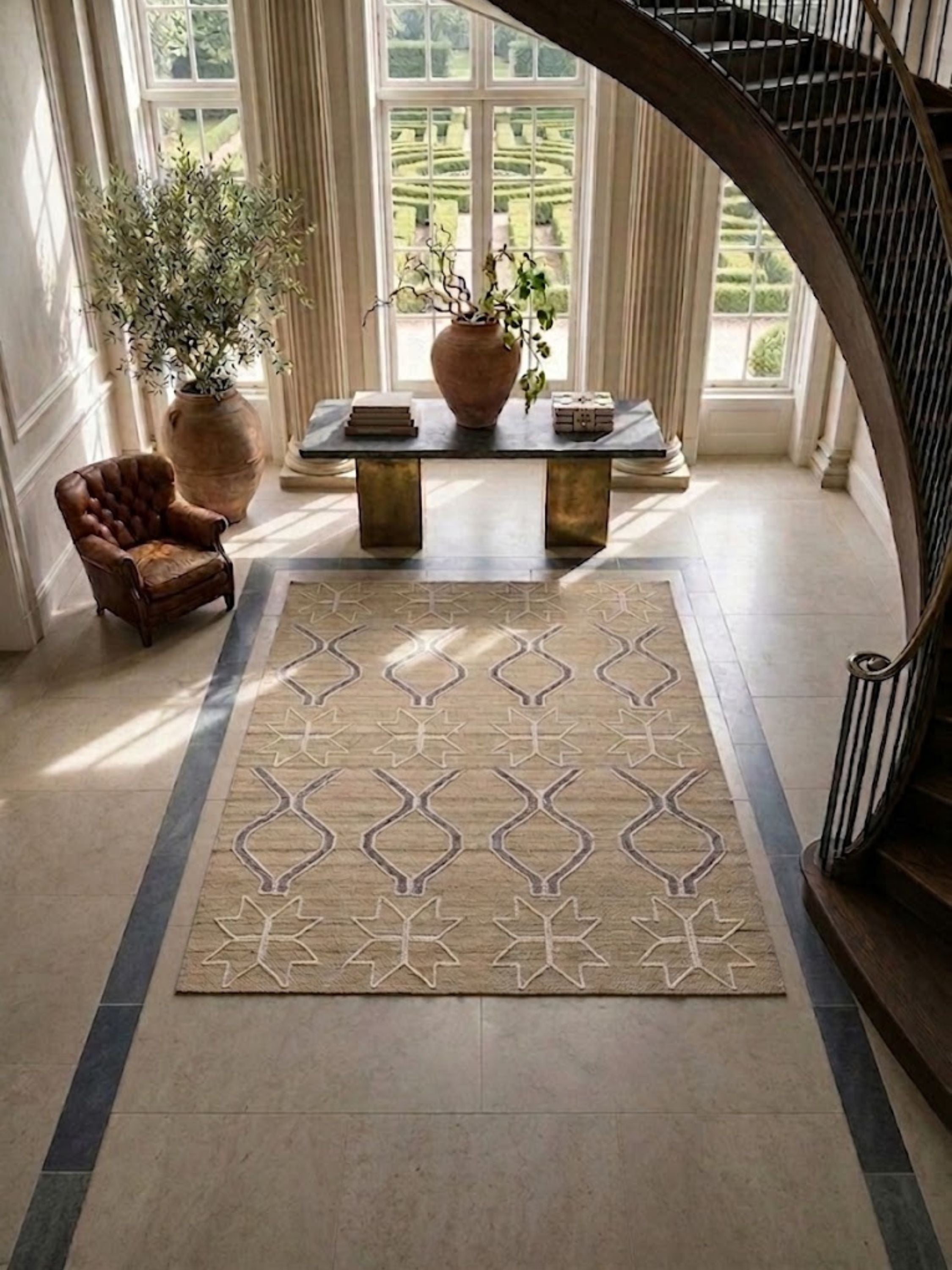 Wool rug with cream and grey-blue geometric motifs, placed in an entryway.