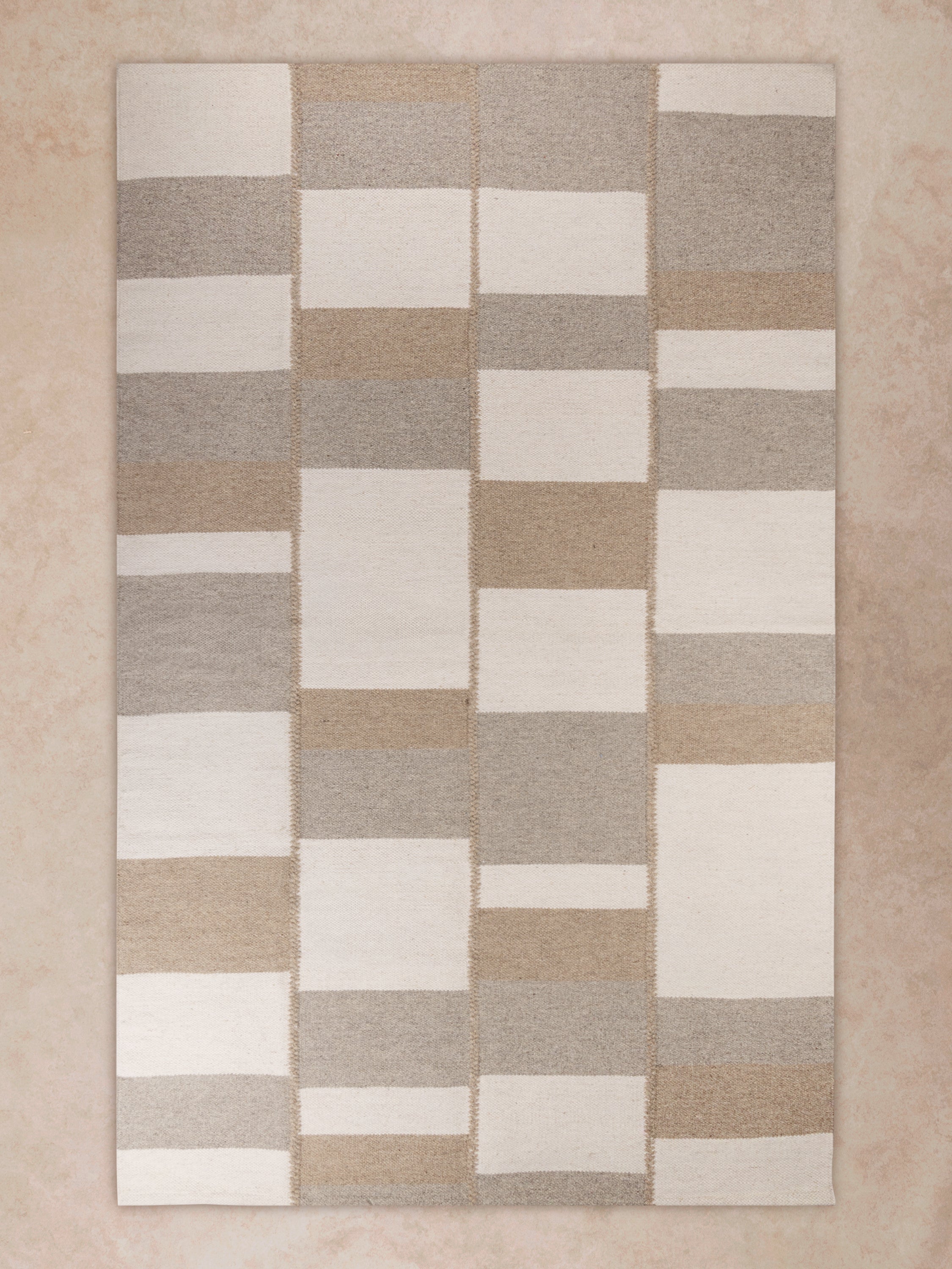 Handwoven Sahara rug with geometric pattern in beige, taupe, and ivory tones made from premium natural fibers