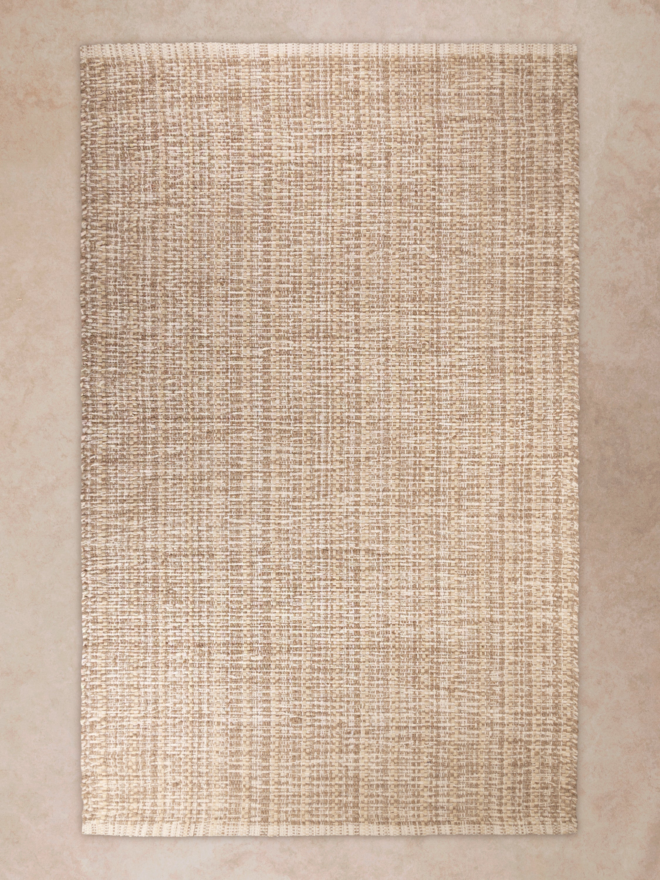 Handwoven Phoenix rug in warm beige and cream tones with rich natural texture