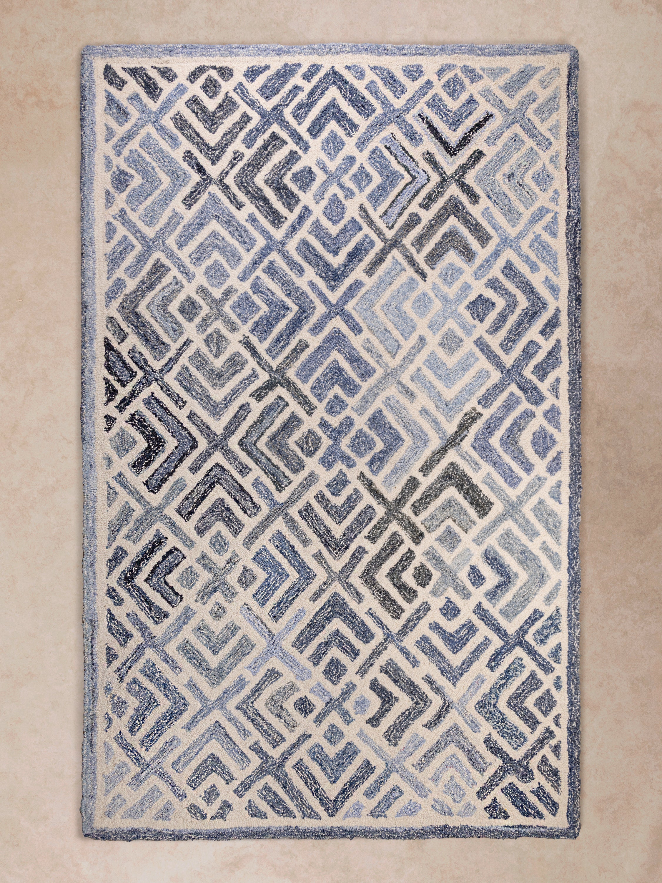 Hand-tufted Santorini rug in blue and ivory with coastal geometric pattern and denim-wool texture