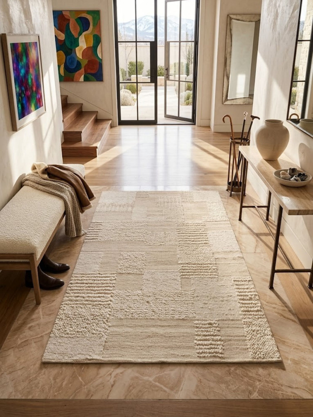 Wool rug combining flat-woven and knotted block constructions, styled in an entryway.