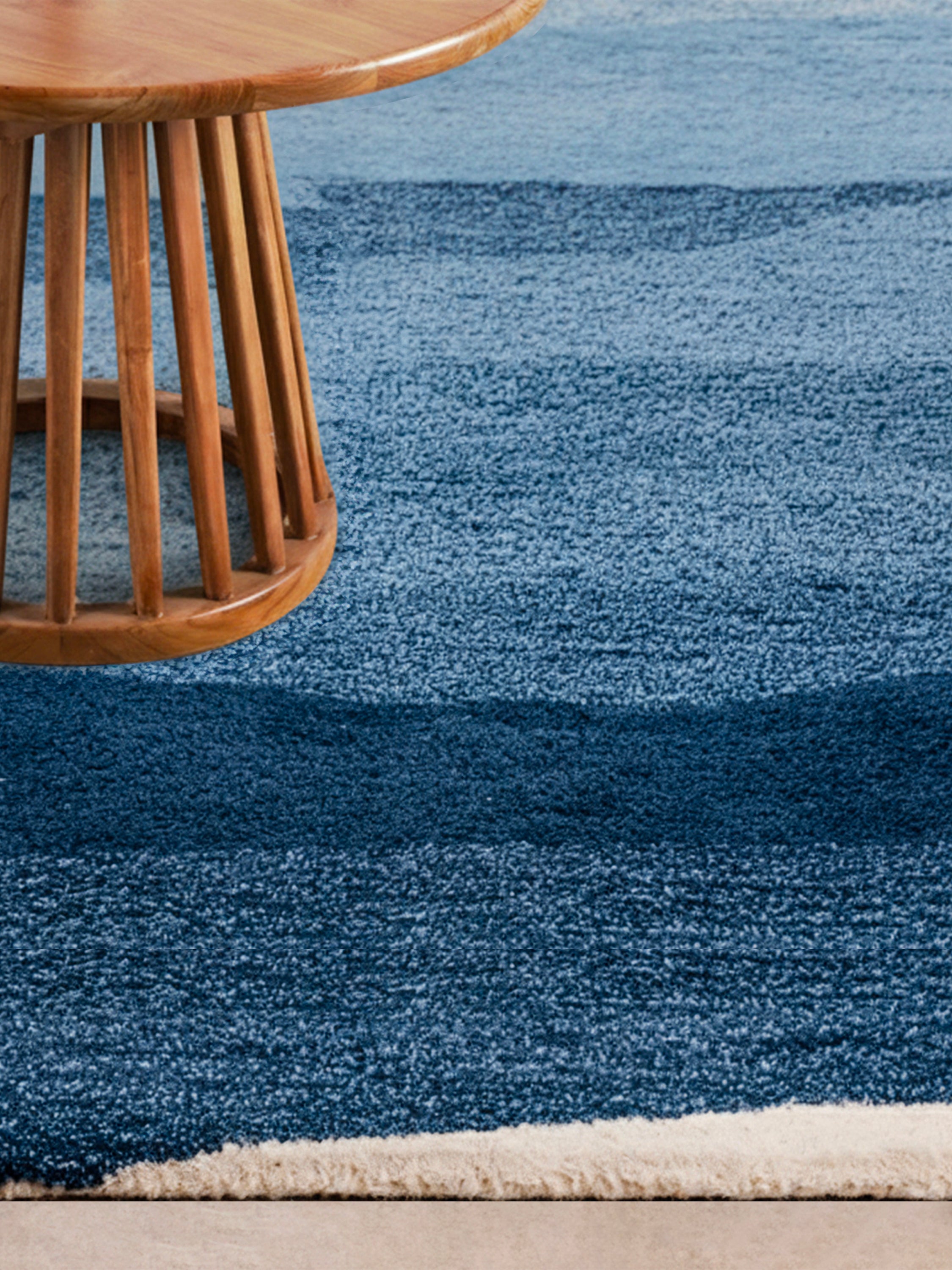 Coastal-style Antigua rug laid flat showing deep navy to pale surf blue ombré design