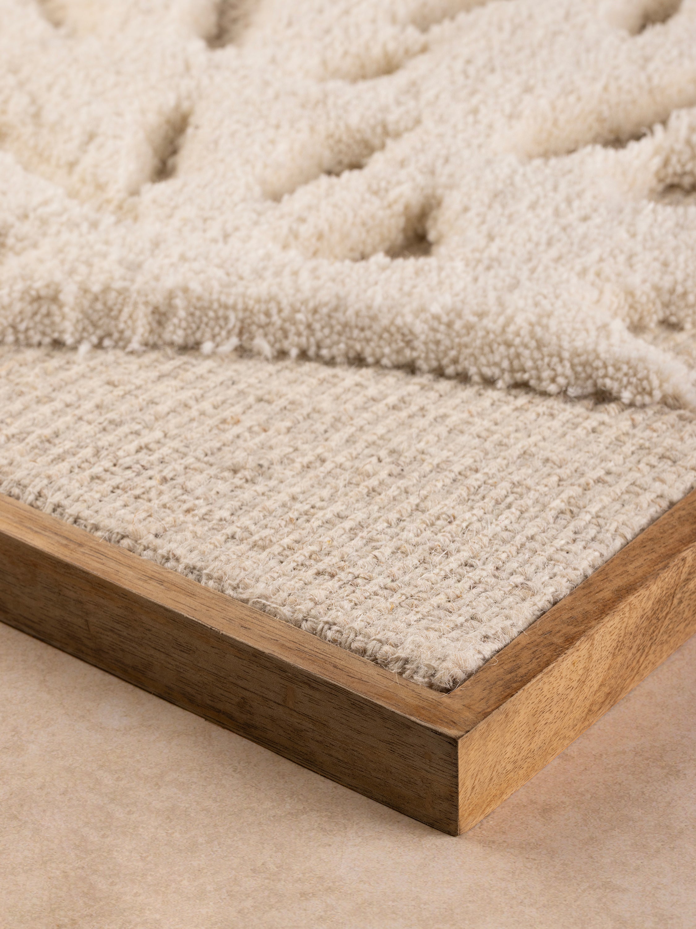 close-up of raised butterfly tufting with natural wood frame