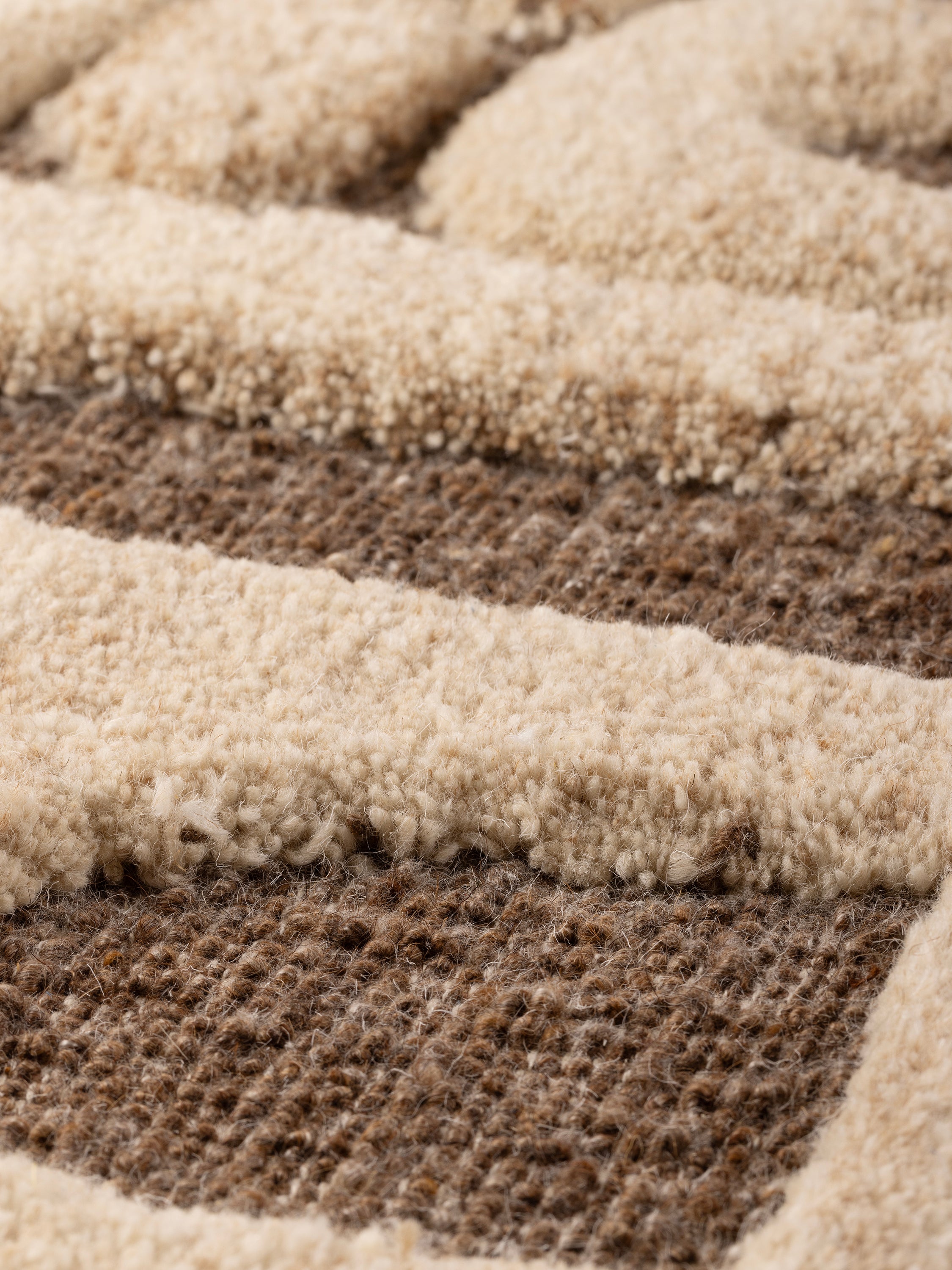 close-up of raised geometric tufting and natural wood frame