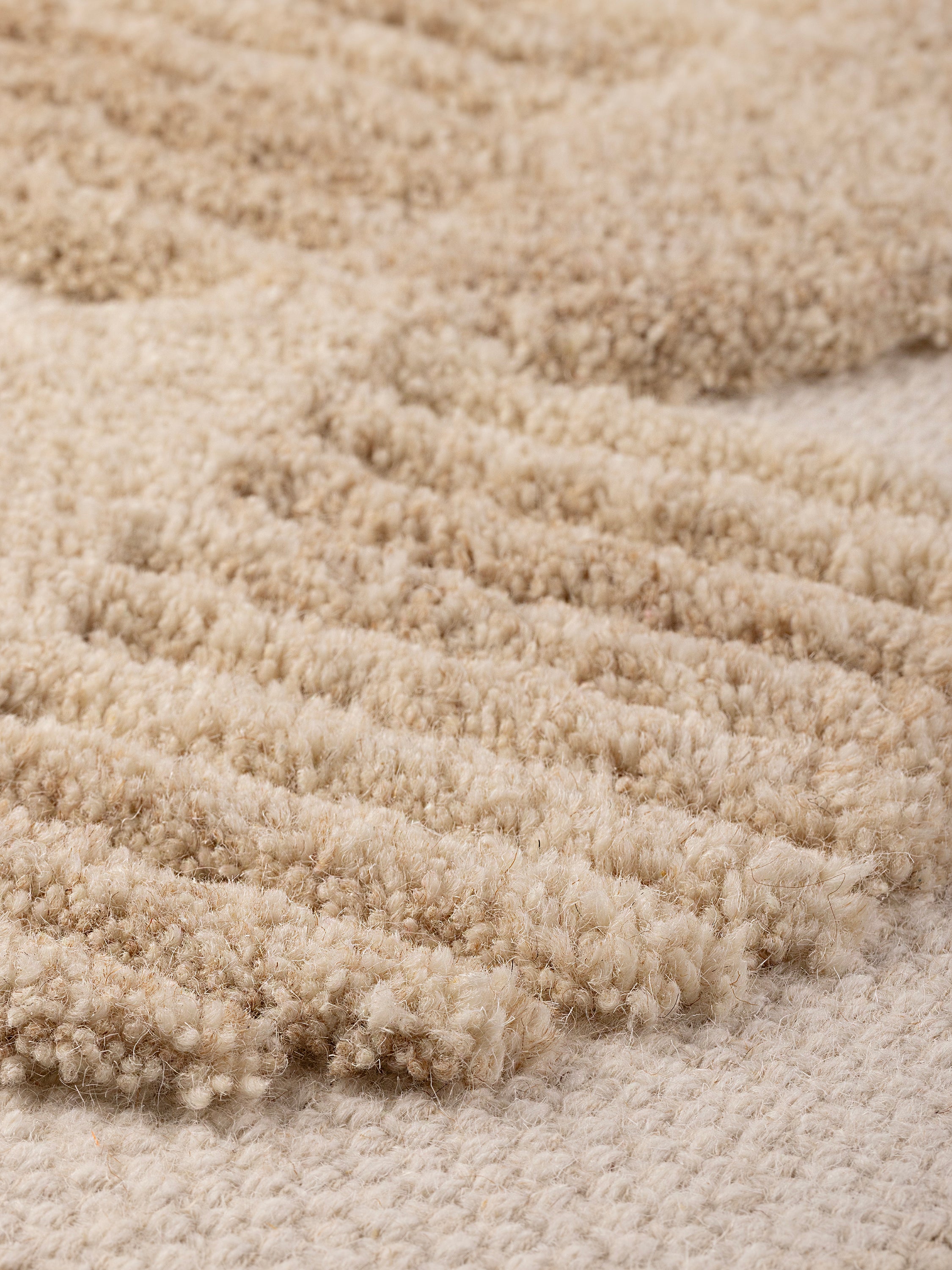 angled view showing raised tufting and woven wool backdrop