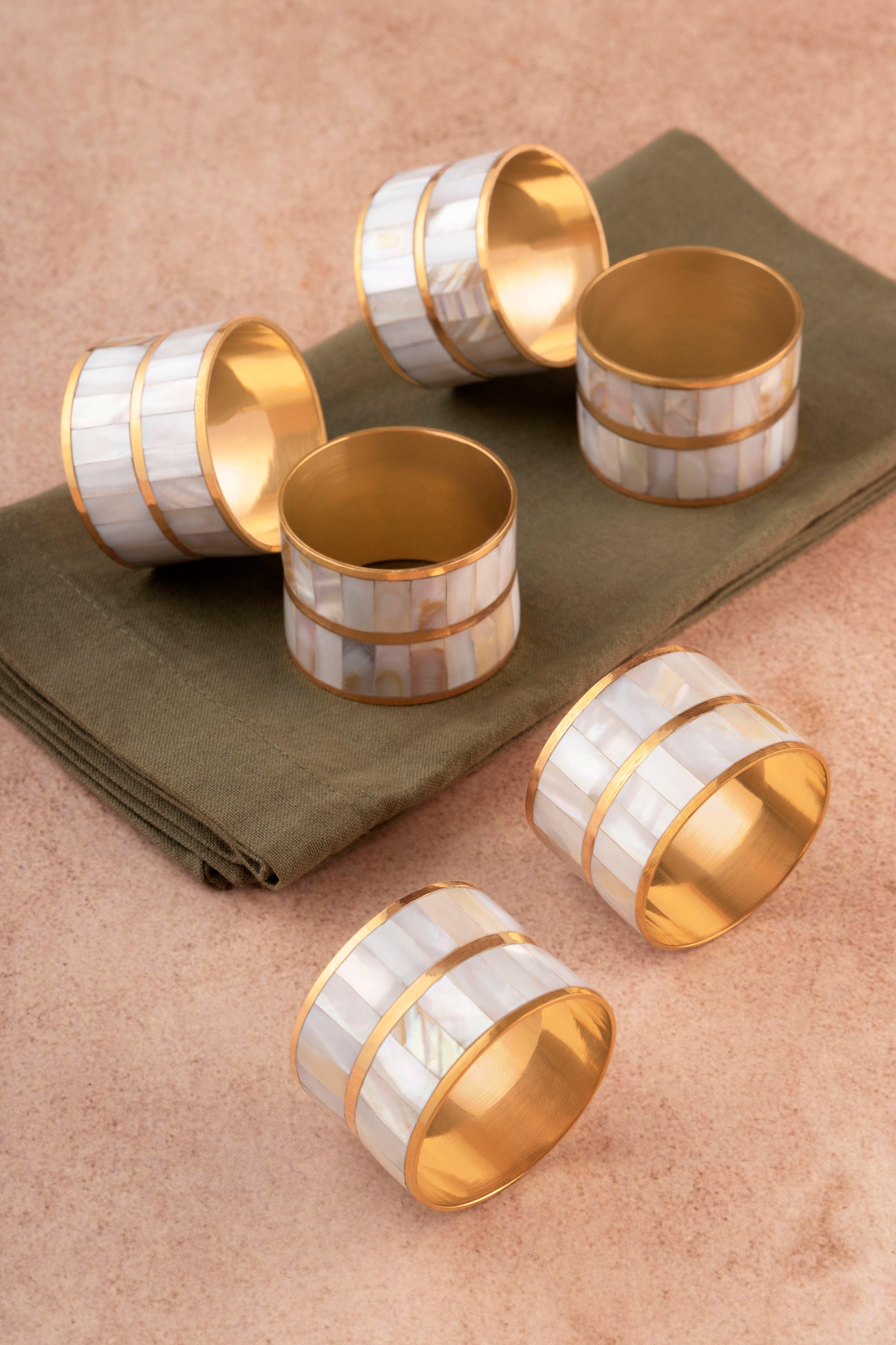 Handcrafted napkin rings in mother-of-pearl and brass — artisan luxury table accent