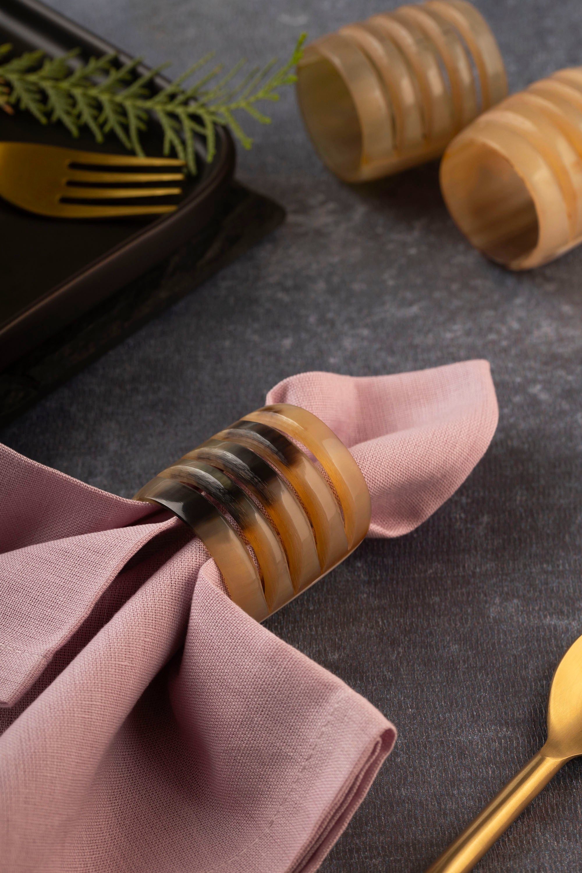 Set of six polished horn napkin rings with natural grain variation — refined dining detail